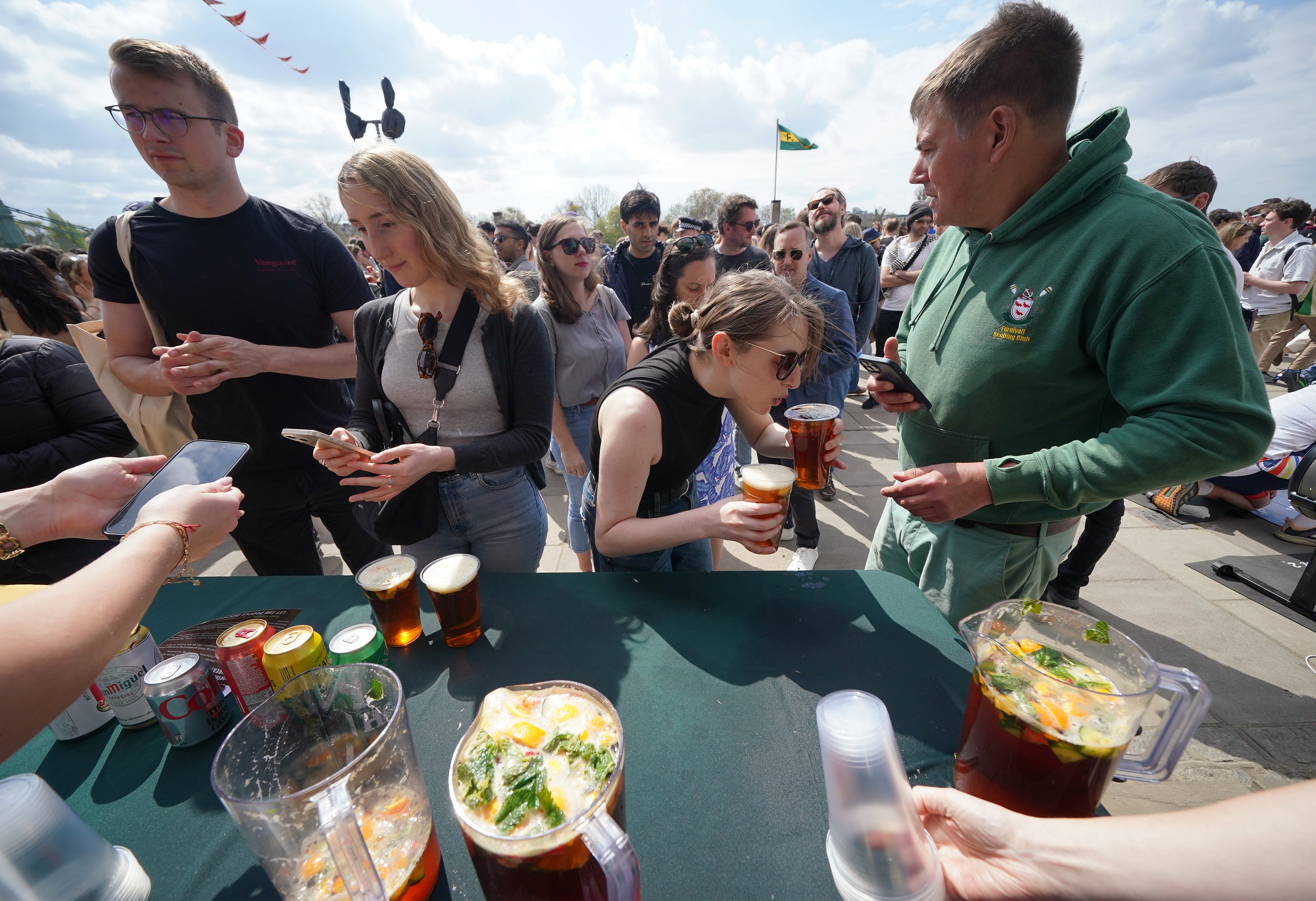 People being served drinks ahead of the Boat Race in Hammersmith, London, before the rain began