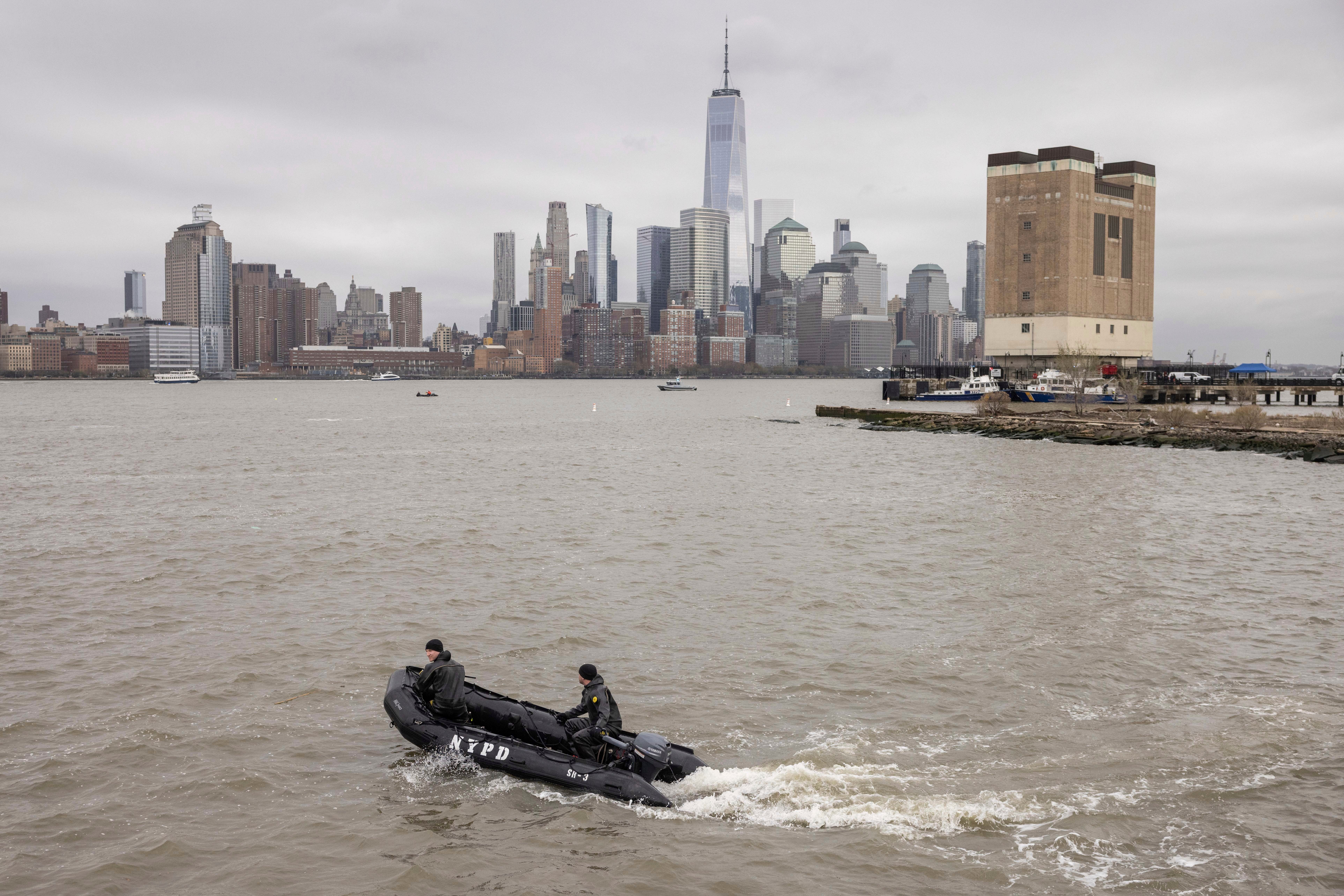 A New York Police Department scuba team looks for debris in the Hudson River