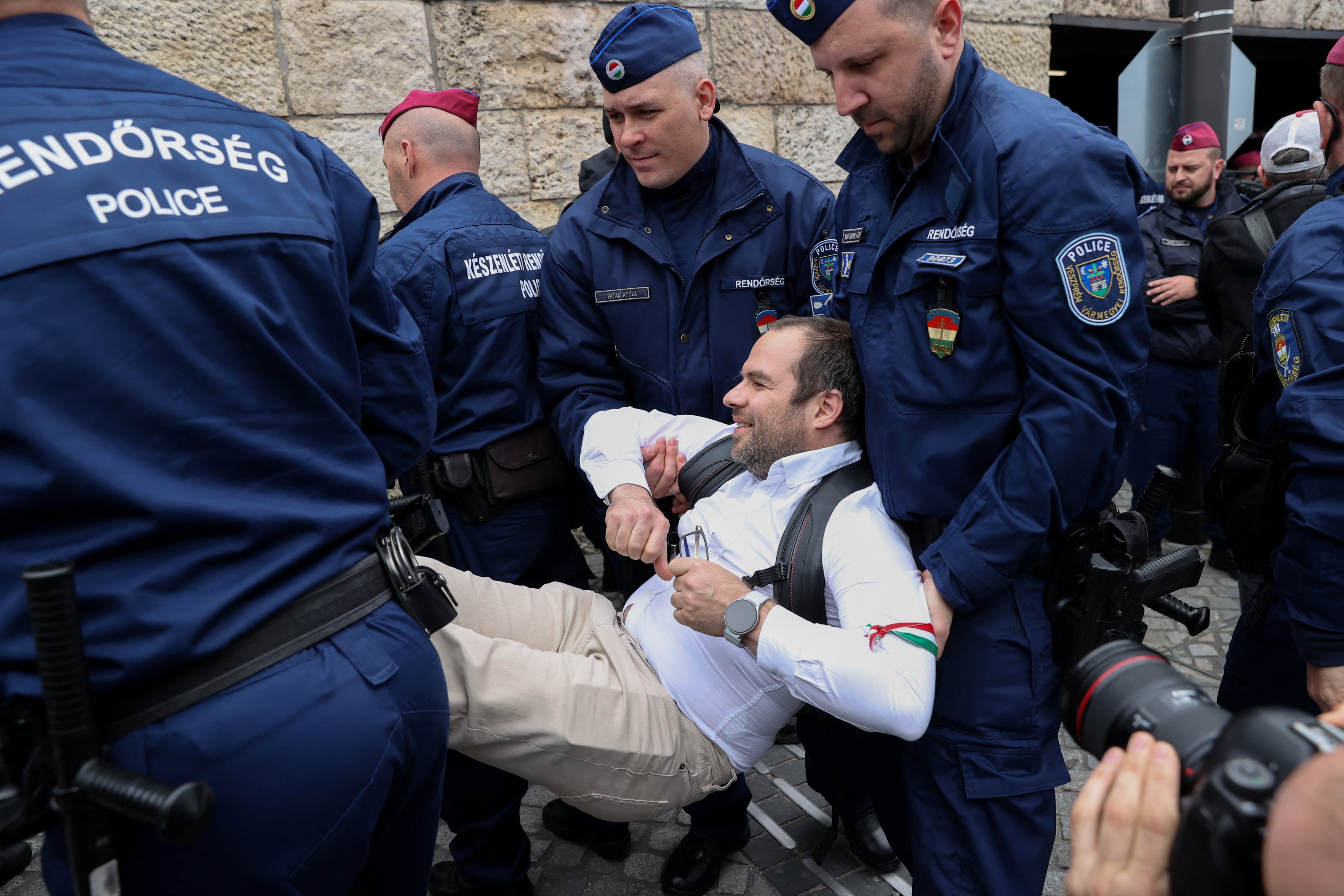 Police officers carry a protester as demonstrators block entrances to parliament