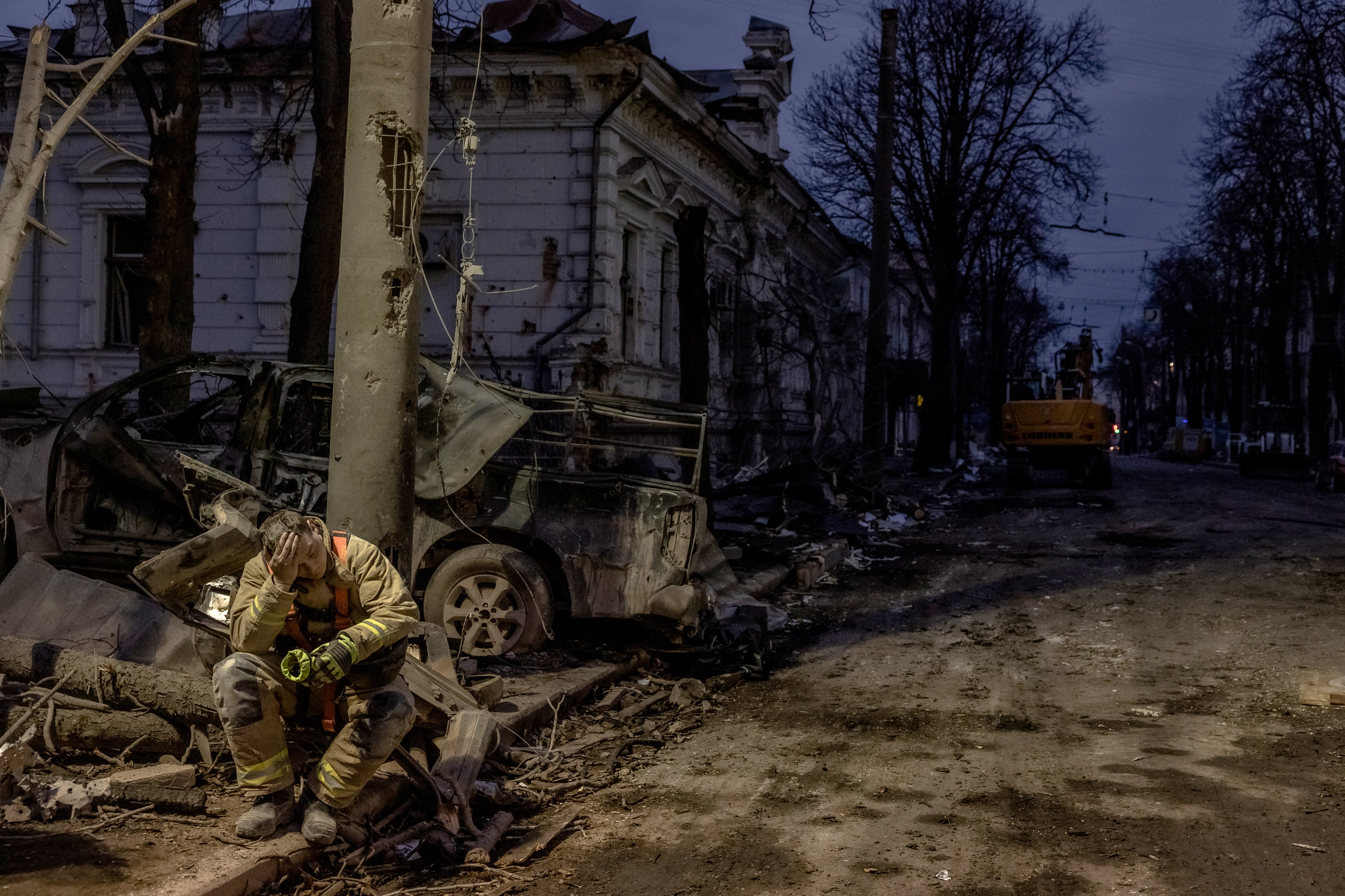 A Ukrainian rescuer takes a break at the site of a missile attack in Sumy, northeastern Ukraine