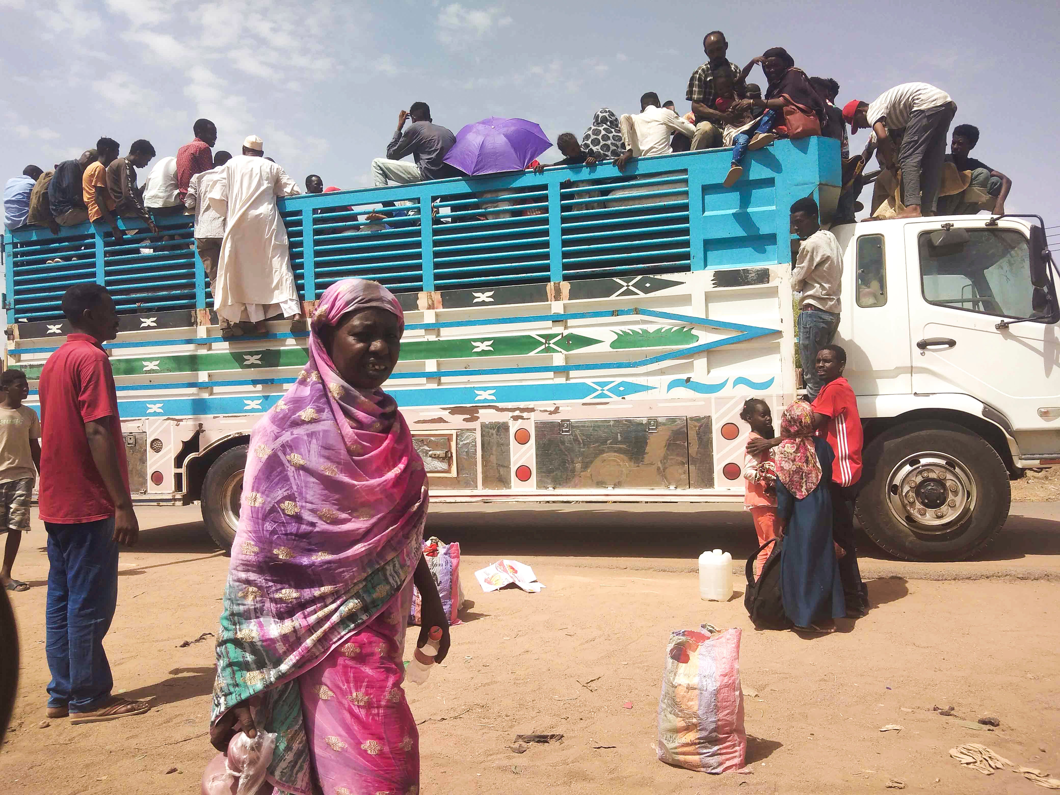 People board a truck to leave Sudan in June 2023