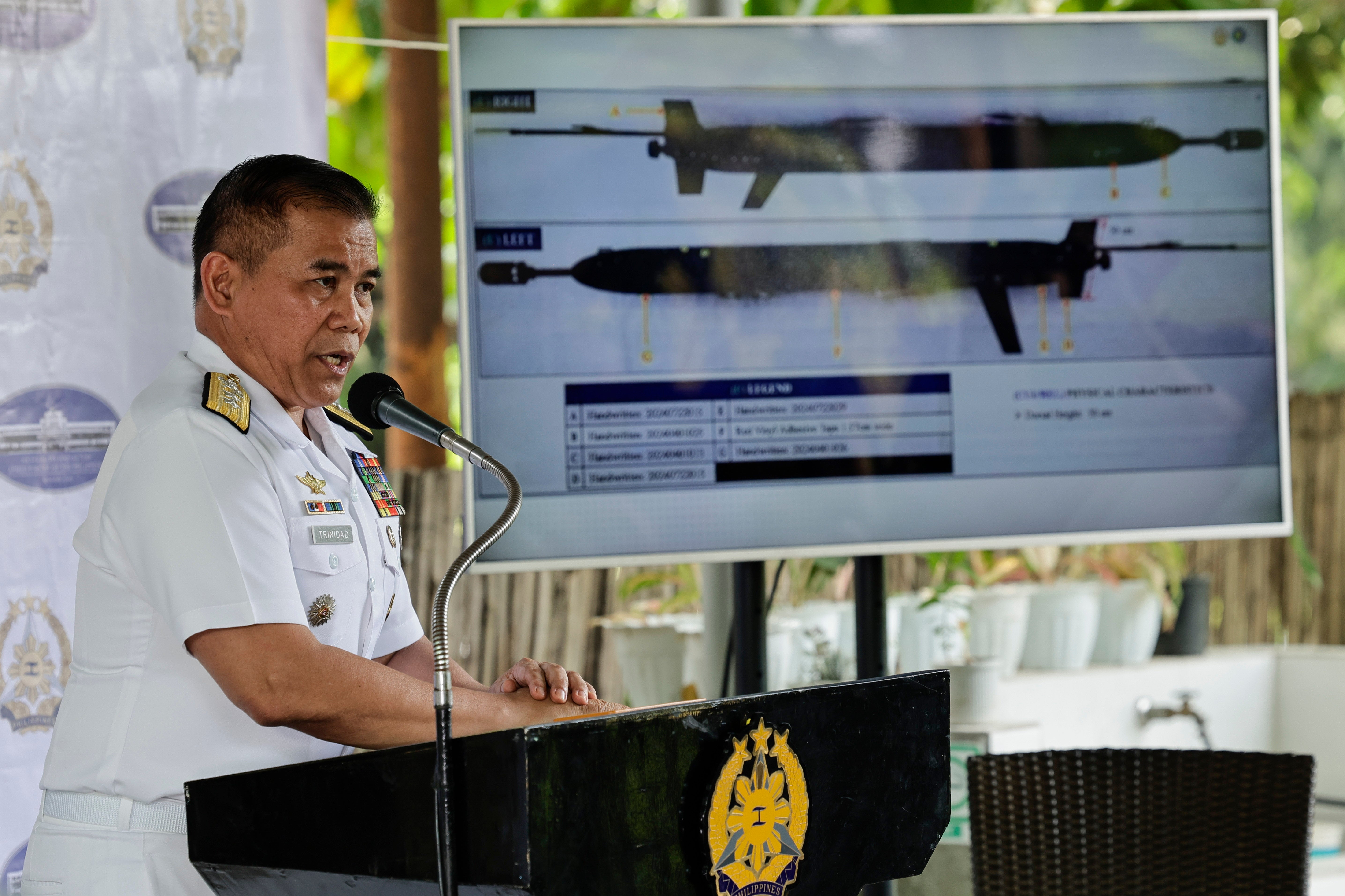 Rear Admiral Roy Vincent Trinidad, Philippine Navy spokesperson for the West Philippine Sea, speaks during a press conference while a submersible drone is projected from an electronic screen at Camp Aguinaldo in Quezon City, Metro Manila, Philippines
