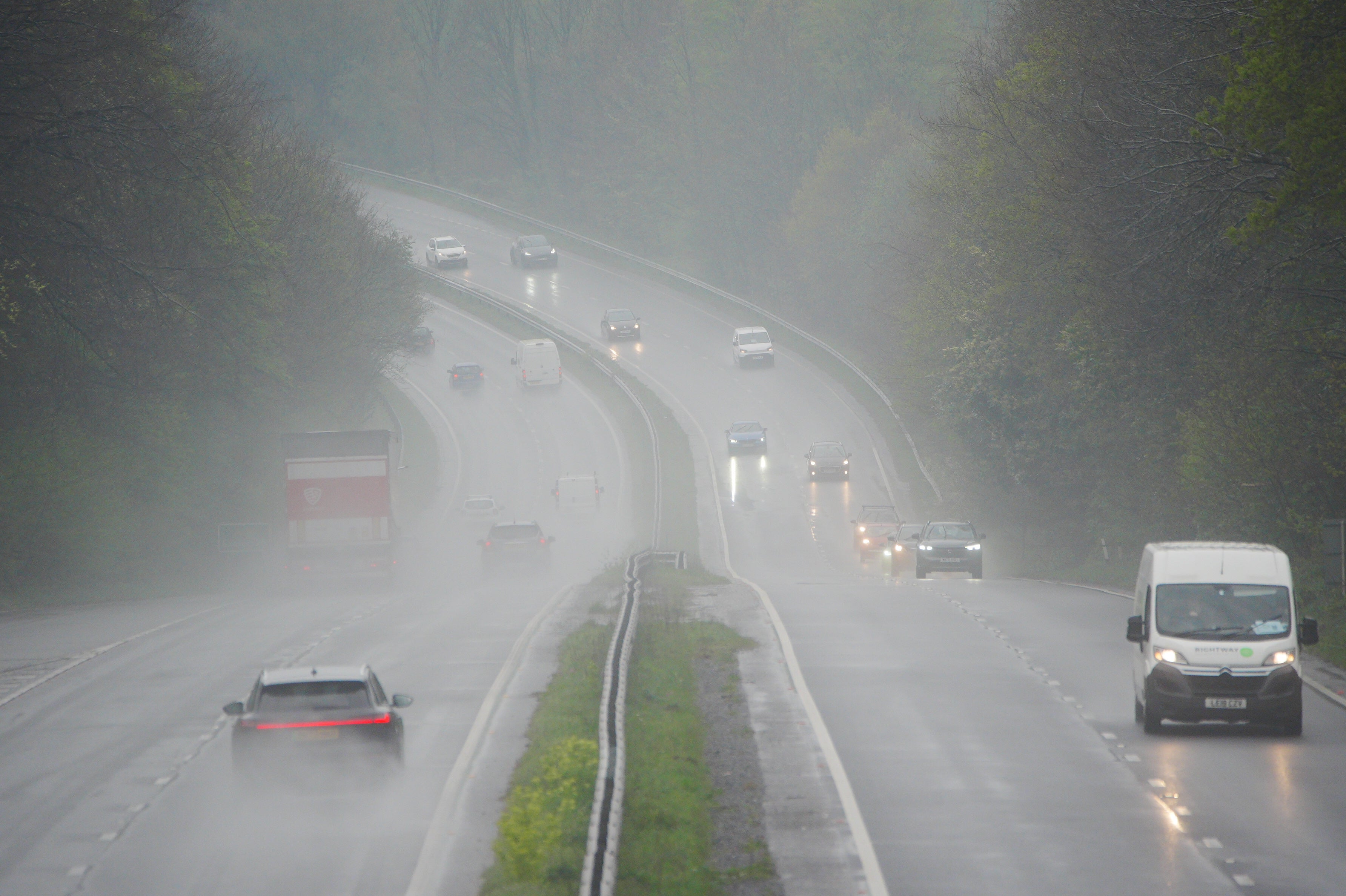 Vehicles drive through rain on the A38 in Plymouth, Devon