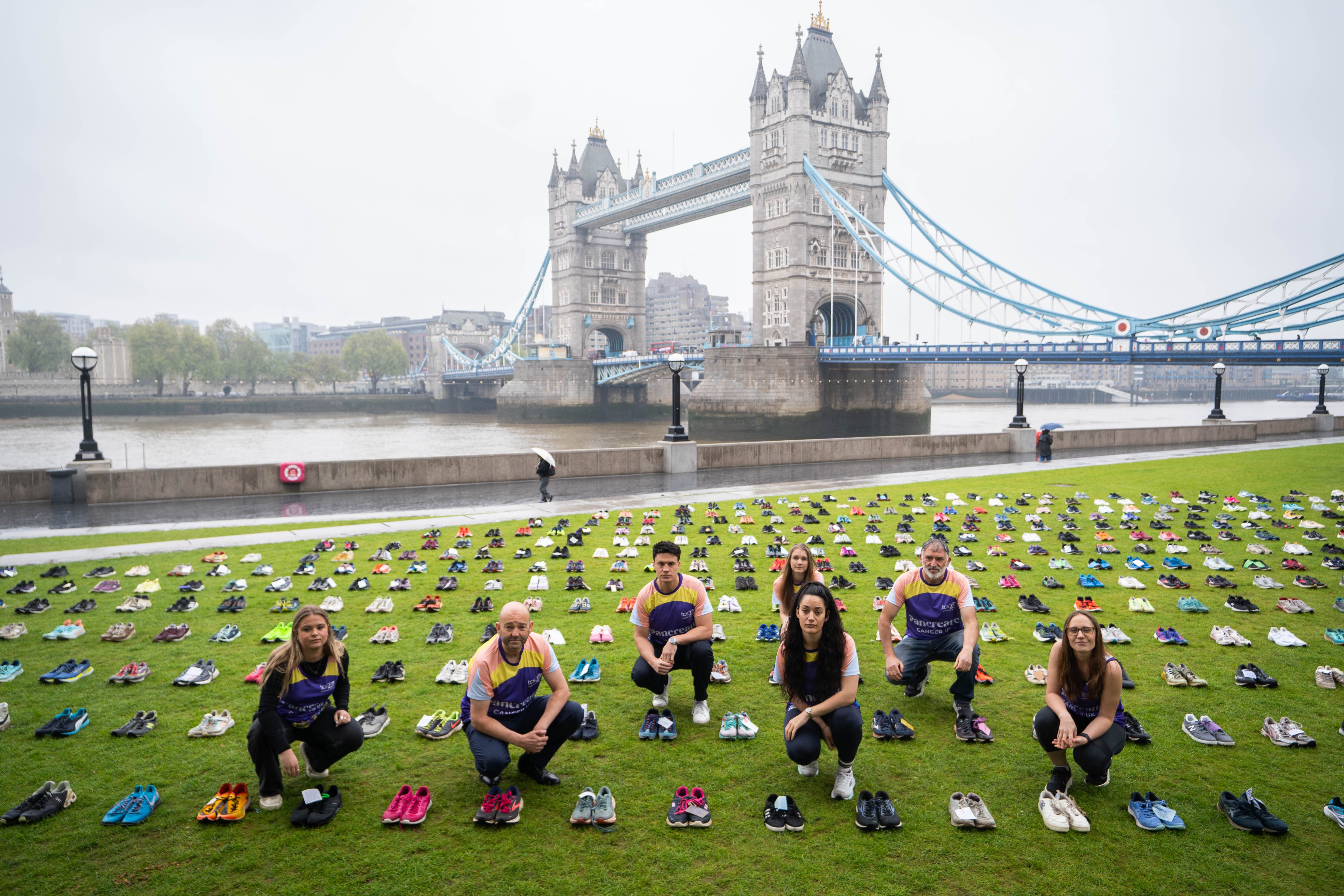 Marathon runners pose amongst shoes during the unveiling of Pancreatic Cancer UK’s installation Shoes of Hope at Potter’s Fields Park in London