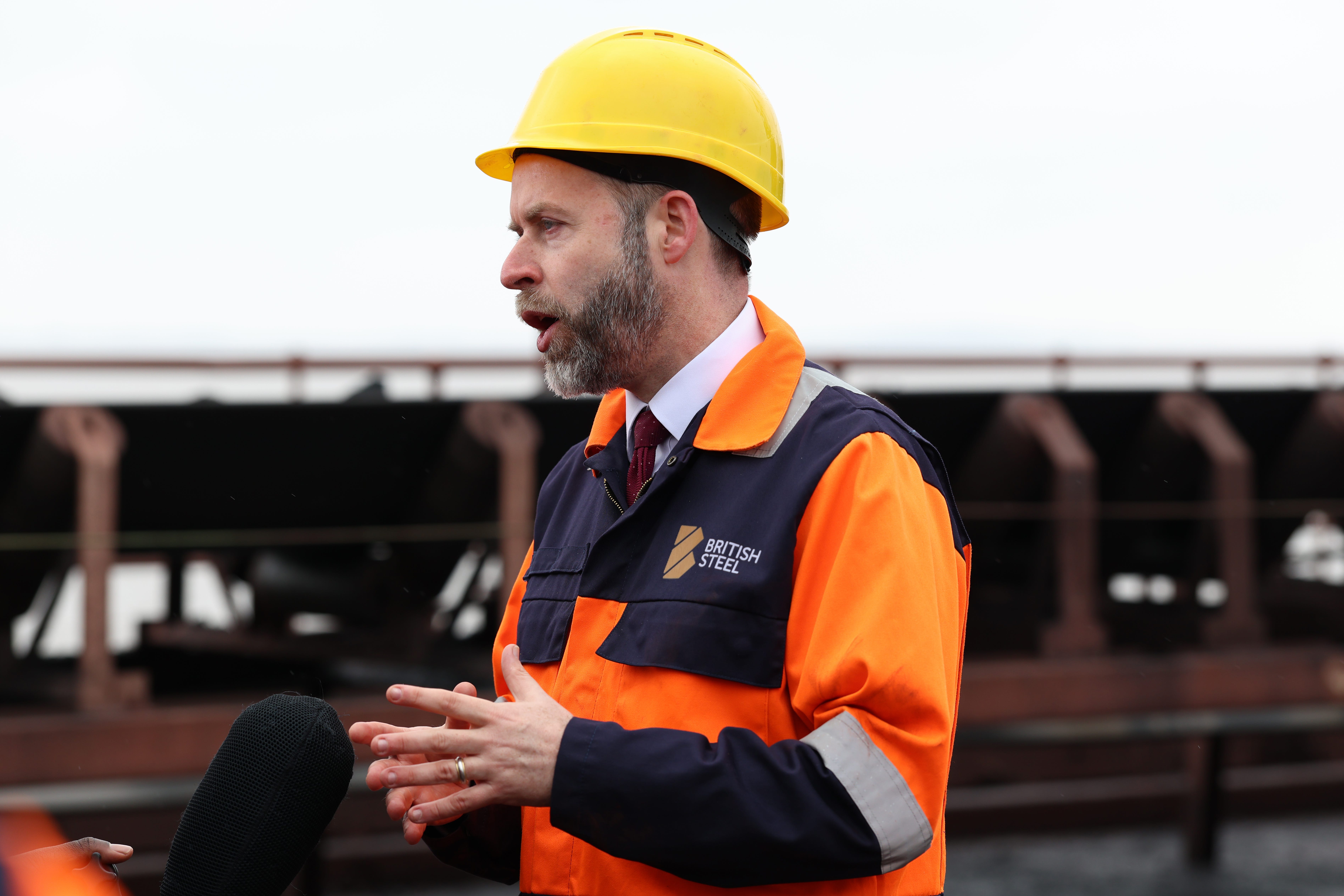 Business Secretary Jonathan Reynolds speaks as coking coal is unloaded at Immingham Port, northern England, as he visits the site in North East Lincolnshire to view raw materials destined for British Steel at Scunthorpe, being off-loaded (Darren Staples/PA)