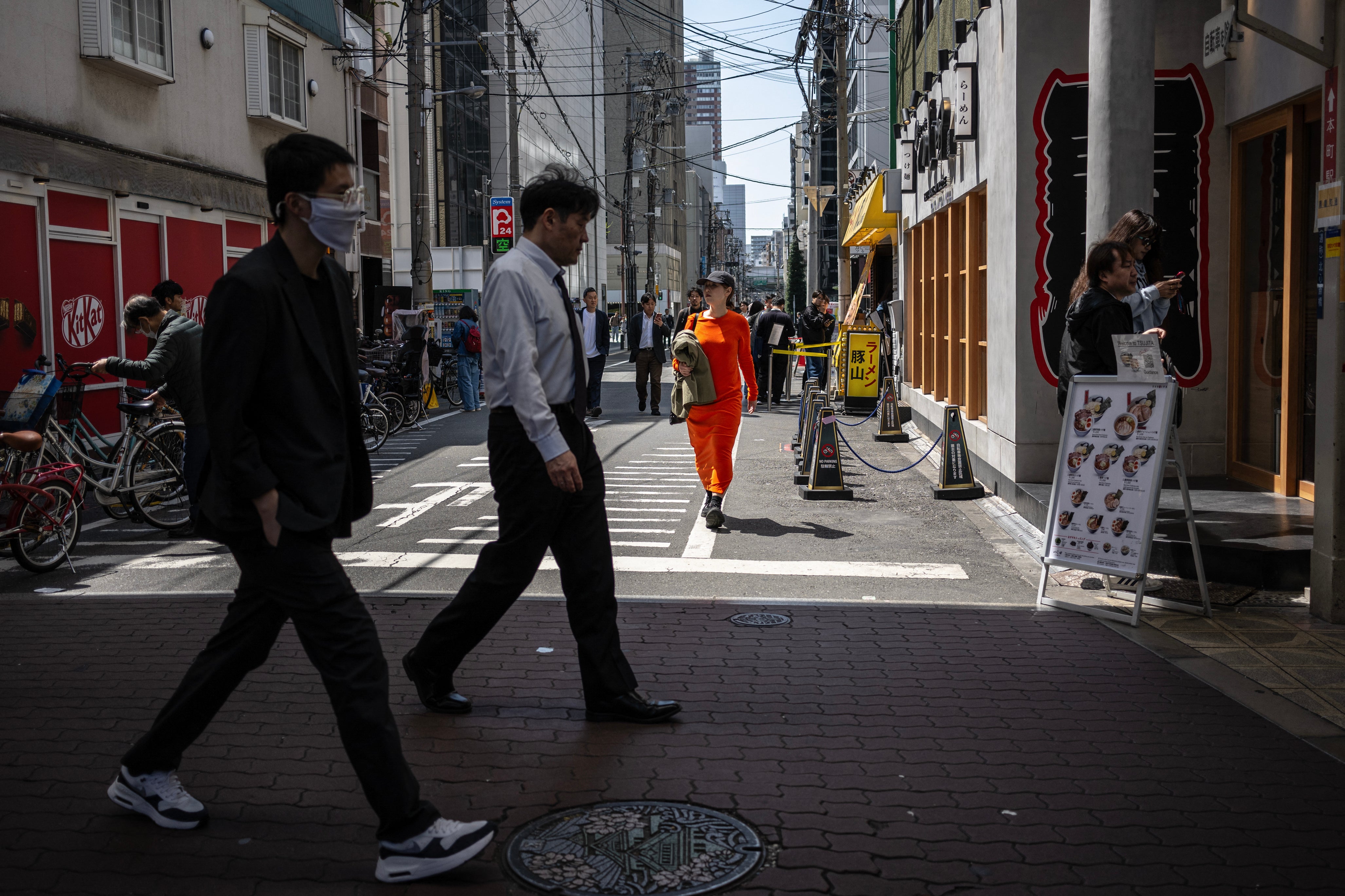 Pedestrians walk along a street in Osaka, Japan