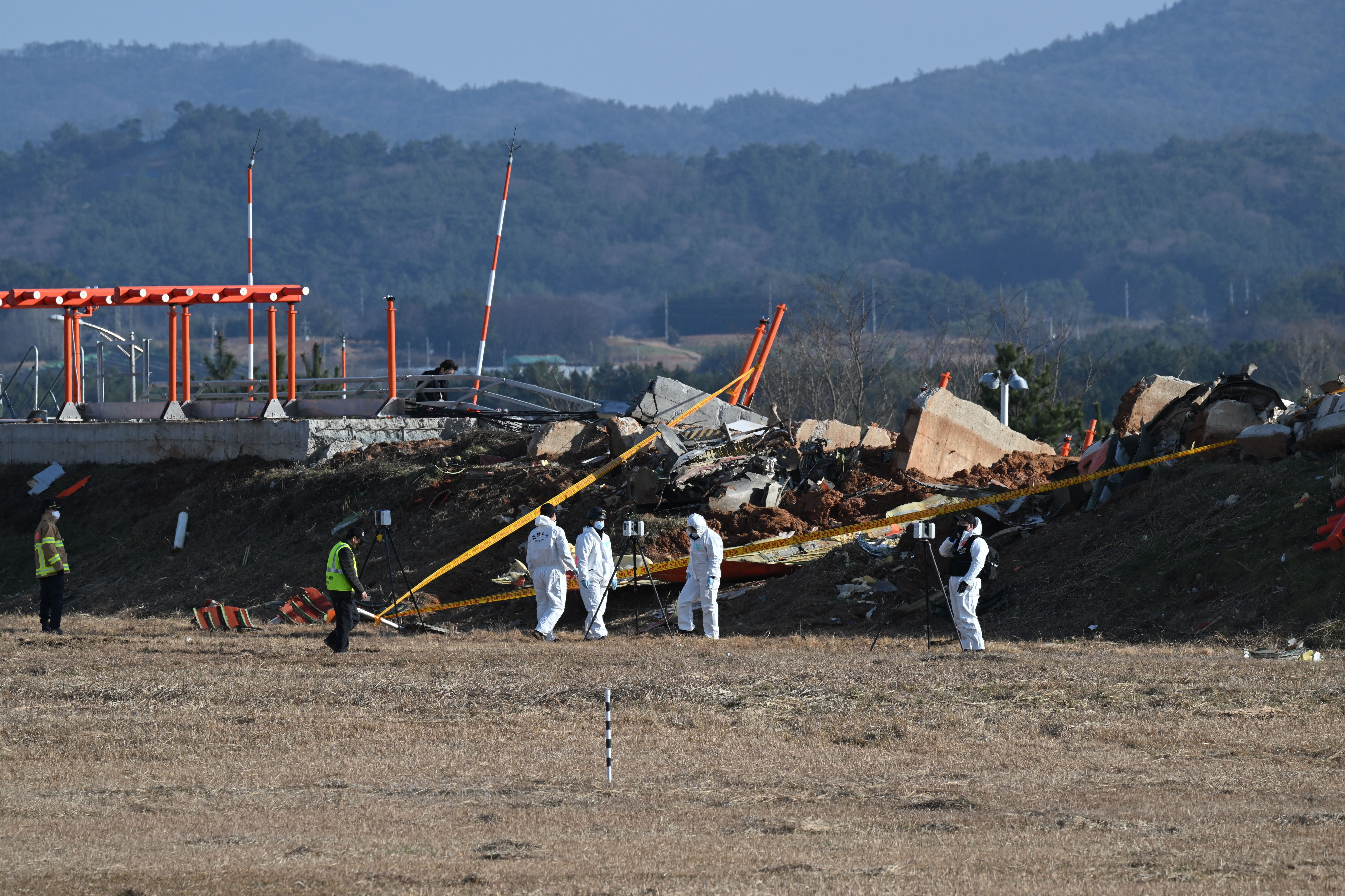 Recovery teams work at the scene where a Jeju Air Boeing 737-800 aircraft crashed and burst into flames at the Muan airport