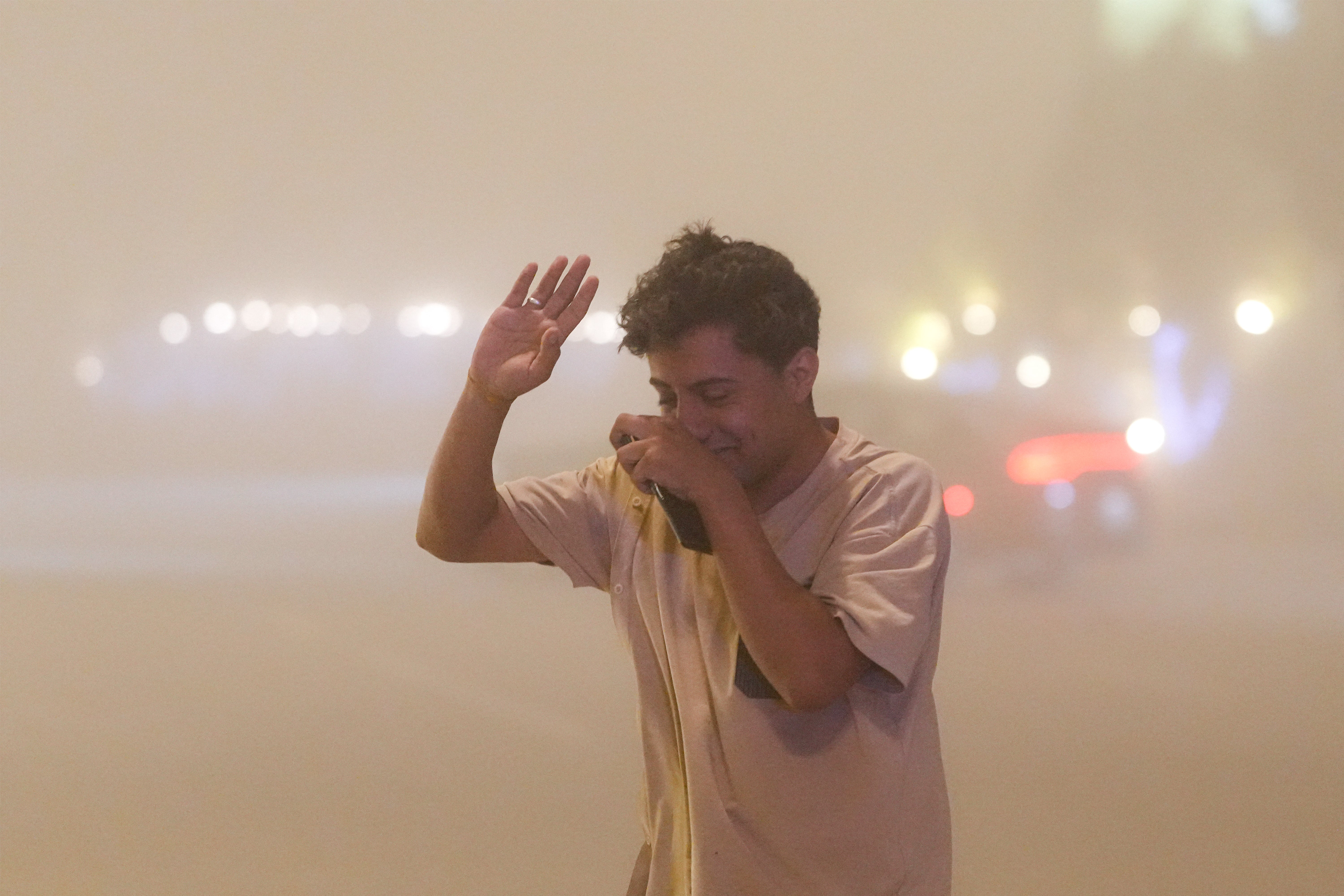 TOPSHOT - A pedestrian struggles to breathe as he walks along the side of a road through low visibility conditions due to a massive dust storm in Iraq’s central city of Najaf on 14 April 2025