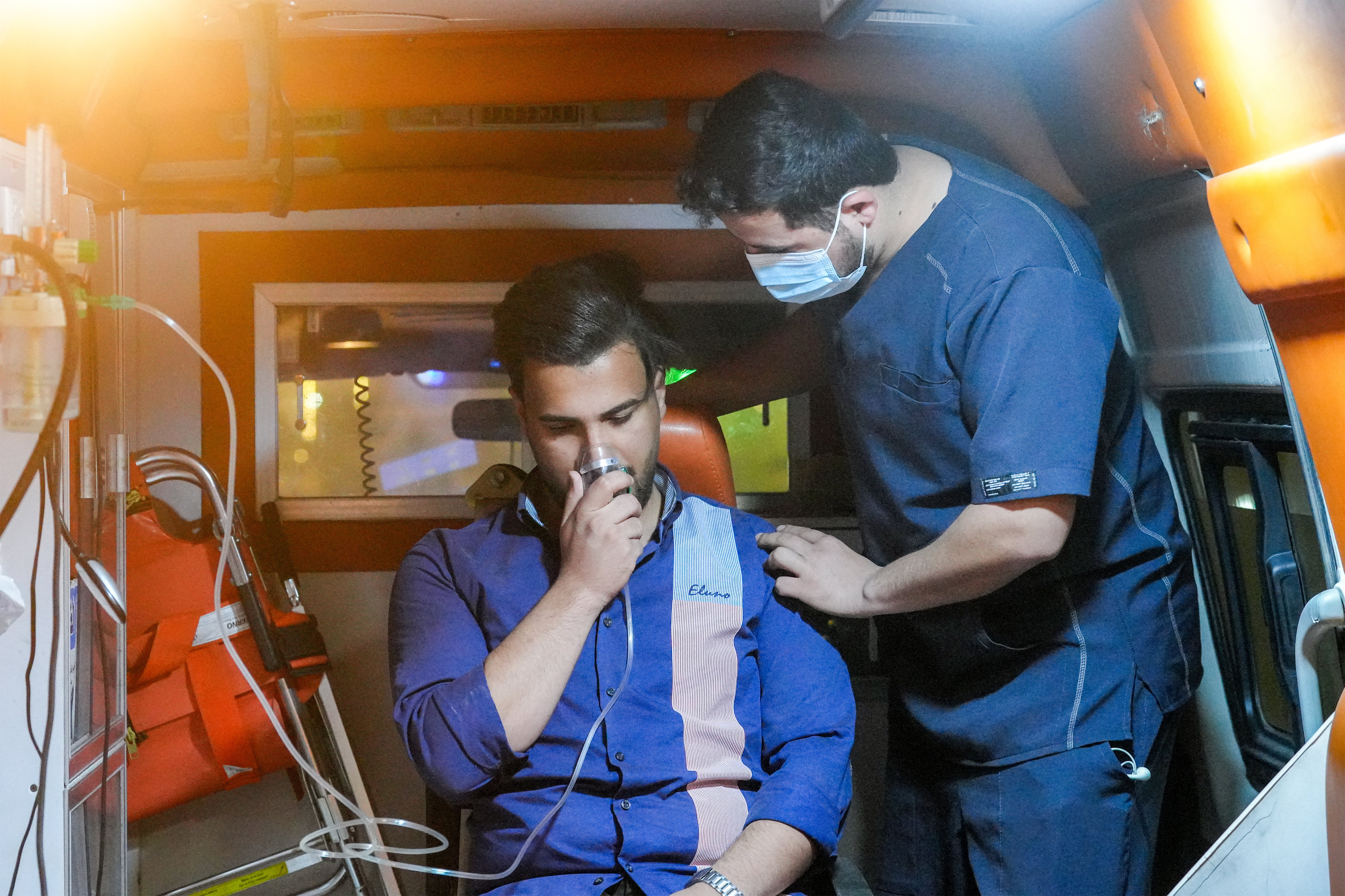 A paramedic in an ambulance helps a person use a respirator as a massive dust storm hits Iraq's central city of Najaf on 14 April 2025