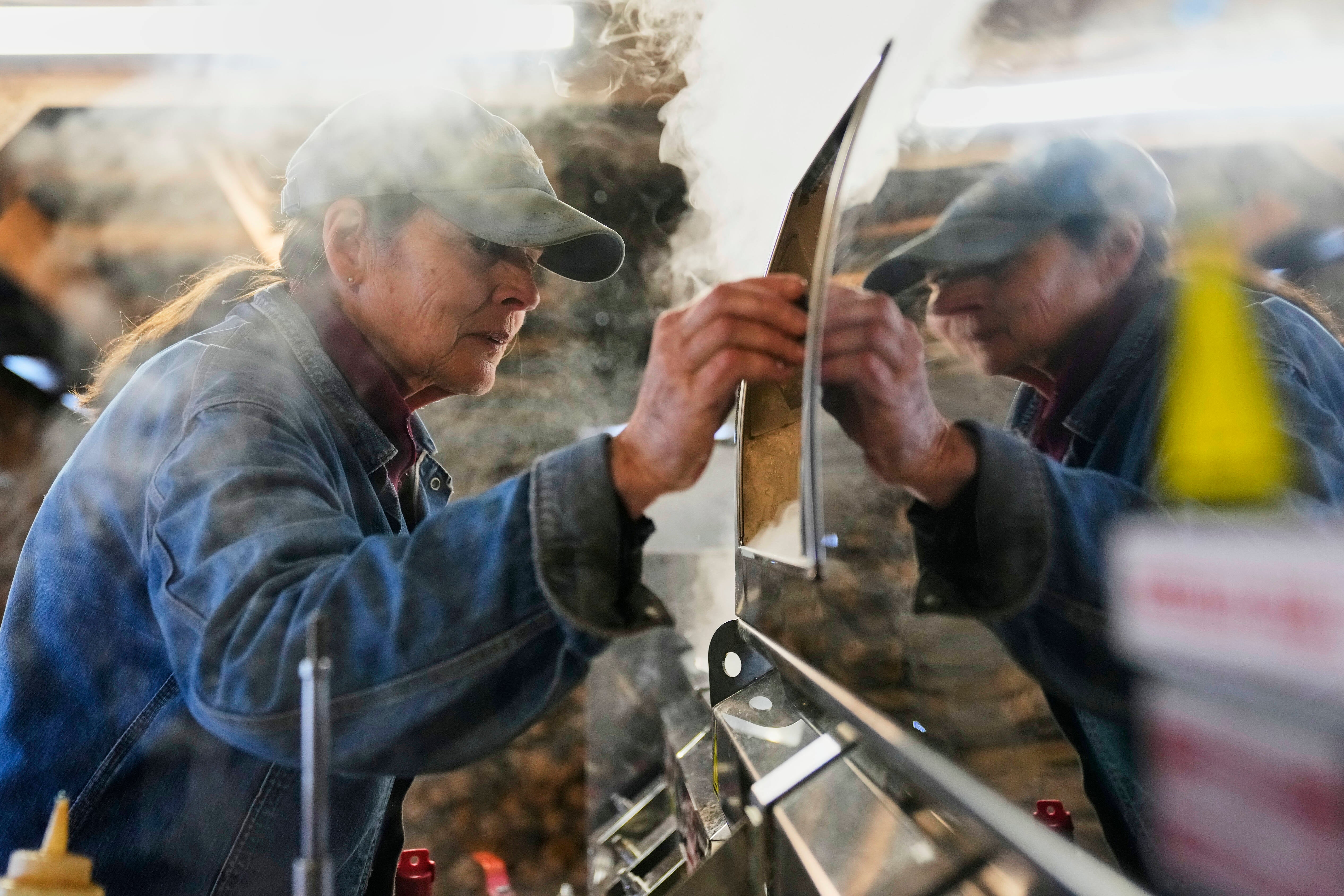 Donna Young checks the Canadian-made maple syrup evaporator in the sugarhouse at Judd's Wayeeses Farms in Morgan, Vt., on Friday, April 11, 2025.