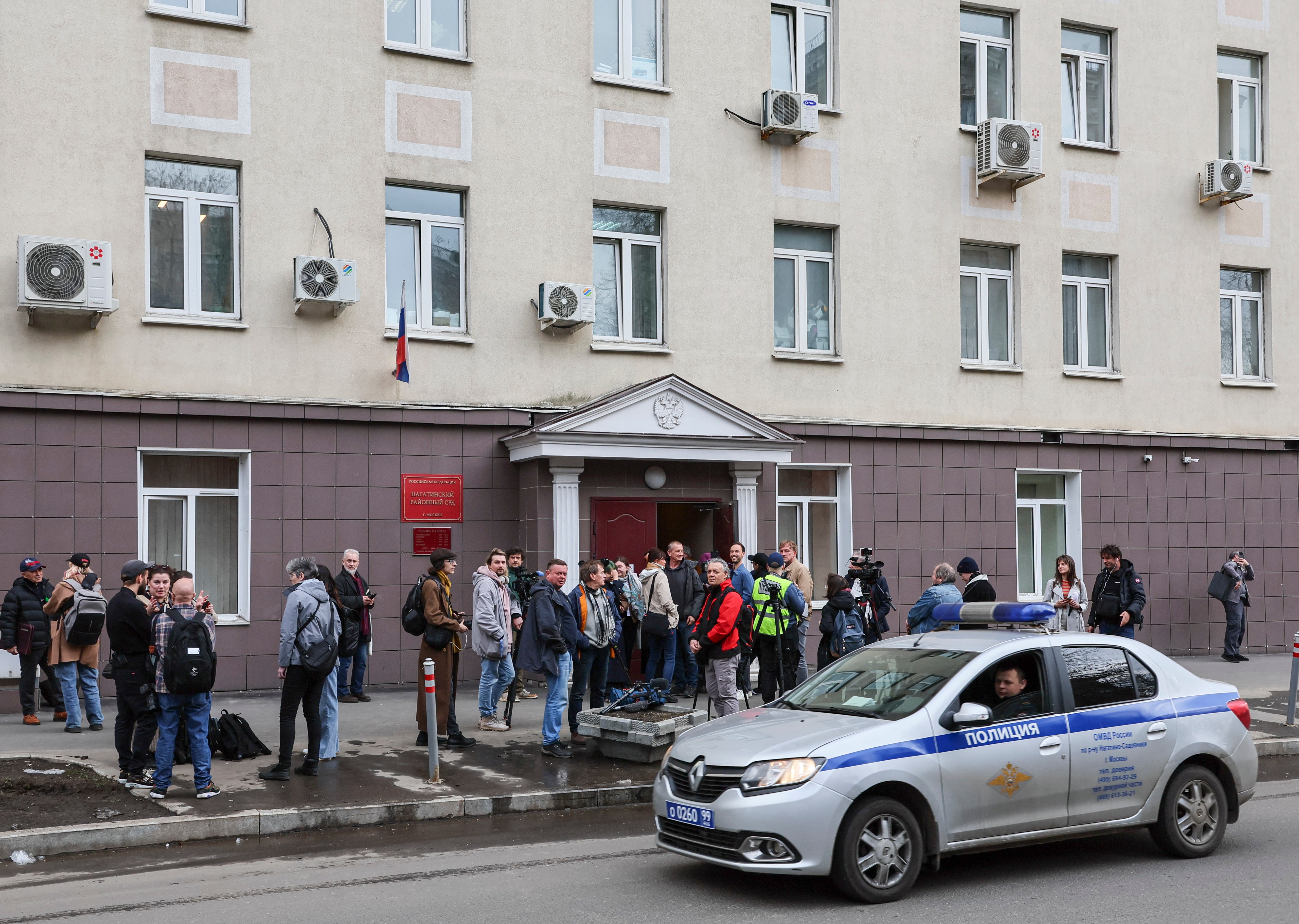 People wait outside a court building to attend a hearing of four Russian journalists at the Nagatinsky District Court in Moscow, Russia, 15 April 2025