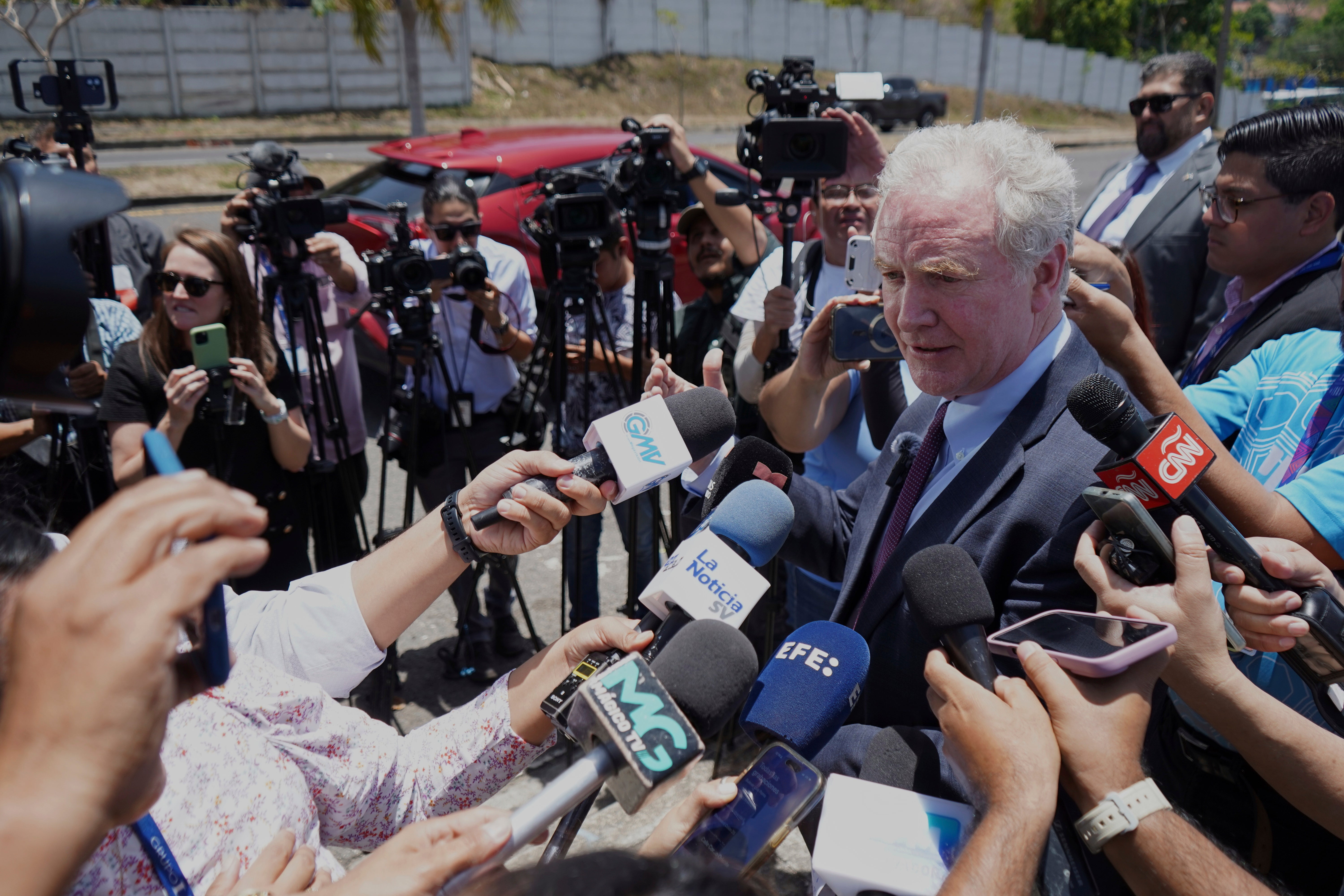 Senator Chris Van Hollen surrounded by reporters in El Salvador on Wednesday