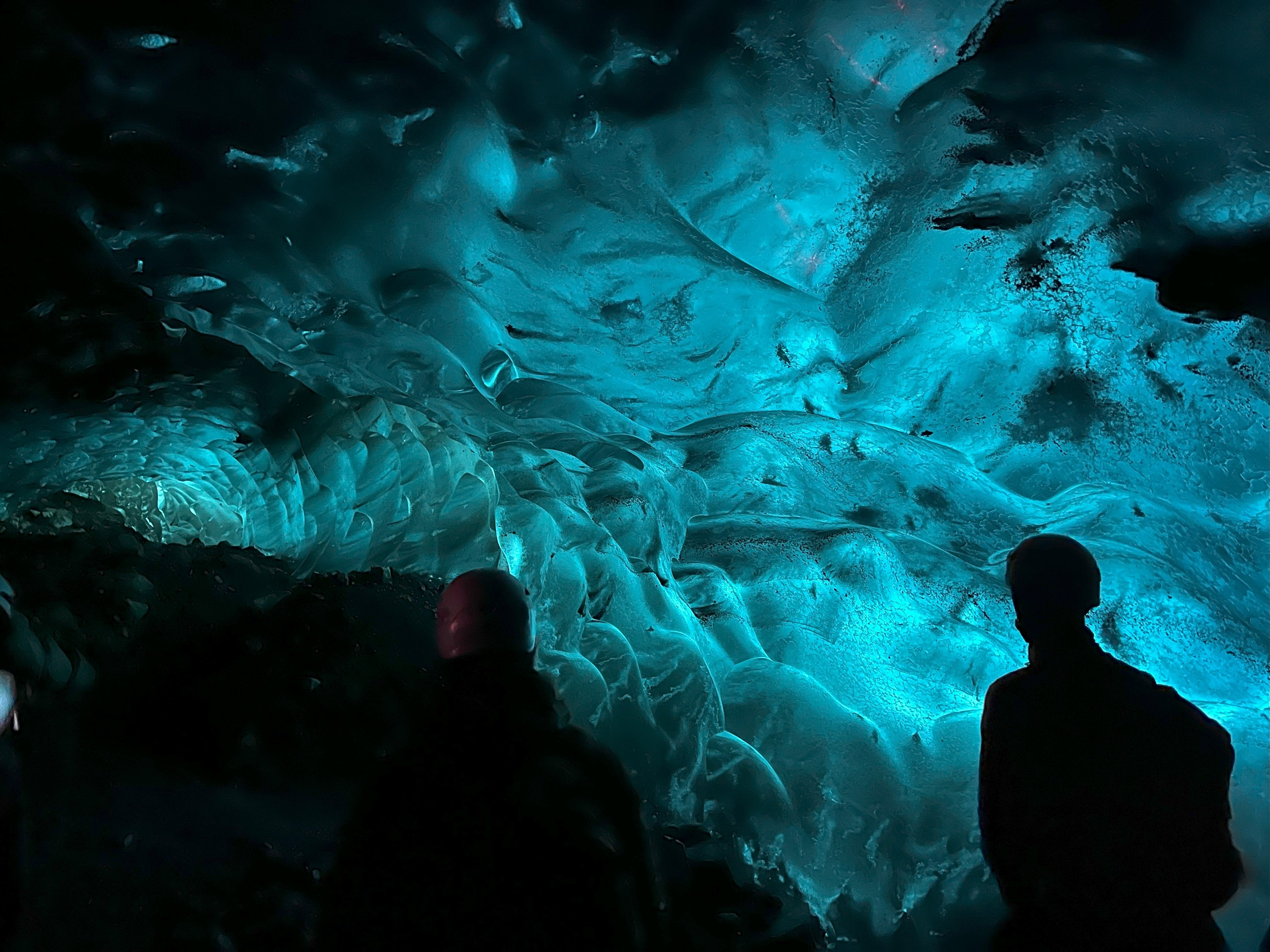 Inside the dark ice cave, a glowing blue light lit up to create this otherworldly phenomenon