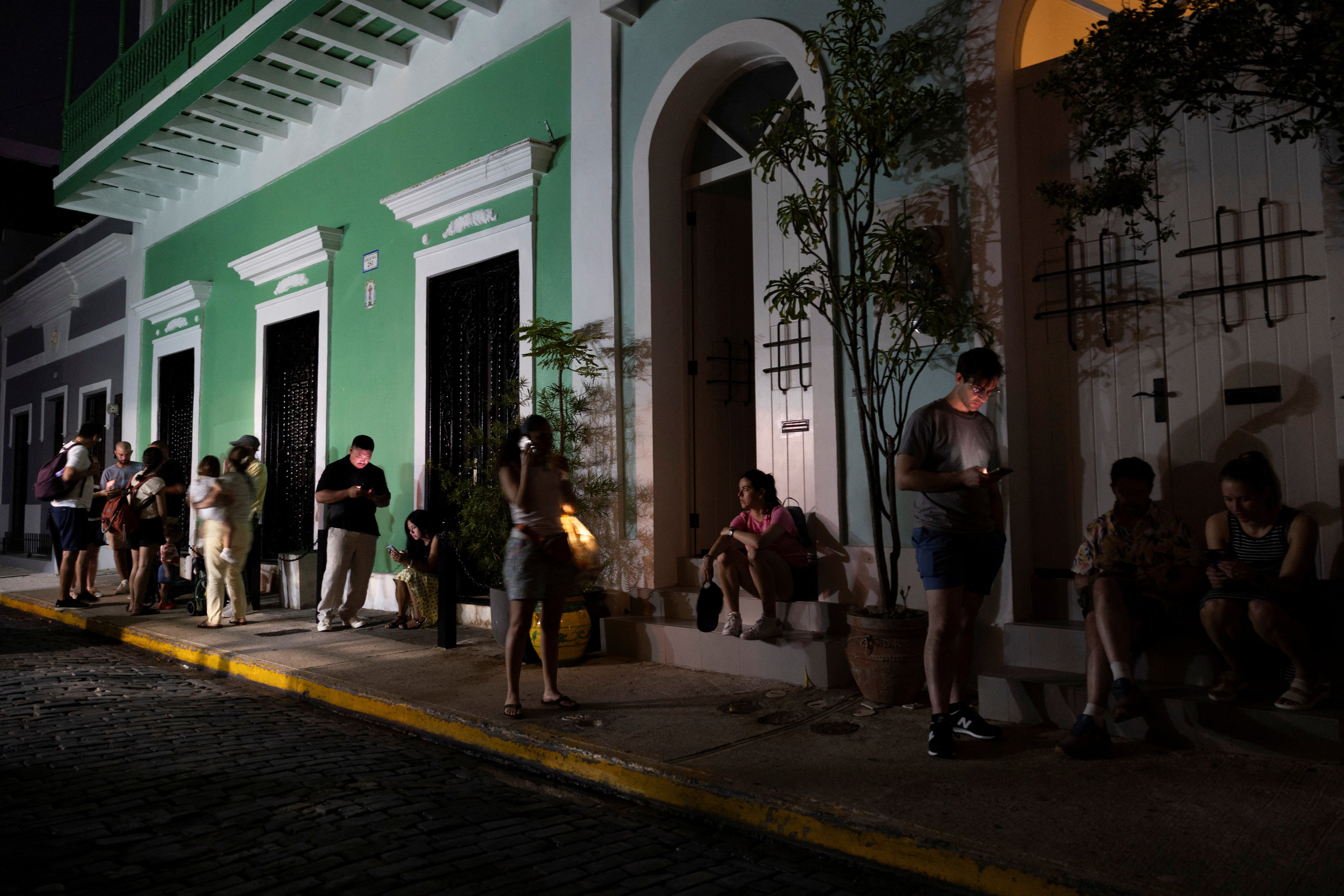People queue near a restaurant in a dark street after Puerto Rico was hit with a massive power outage where energy plants across the island unexpectedly shut down