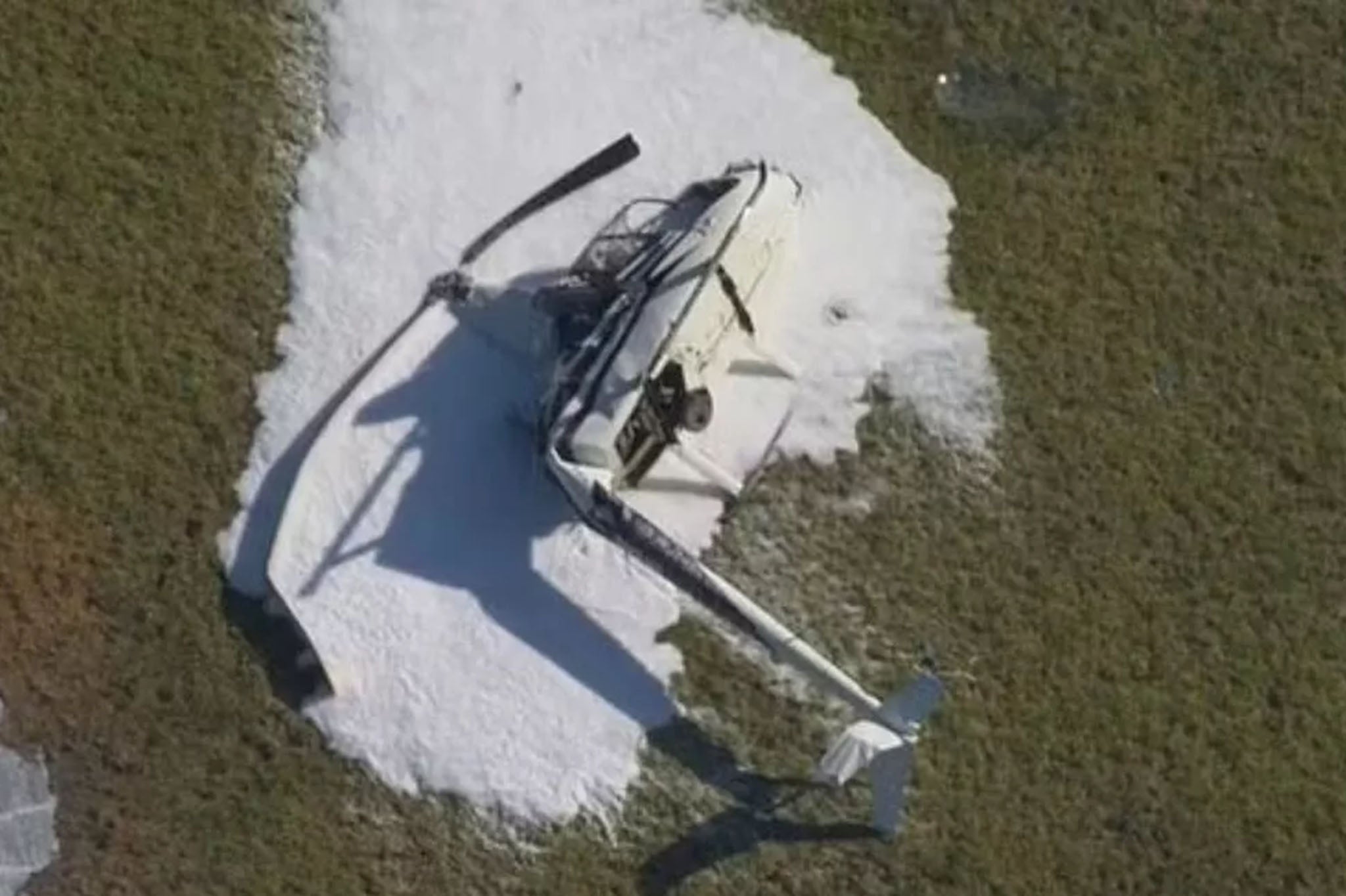 Visuals from the scene showed the crumpled remains of the helicopter doused in firefighting foam