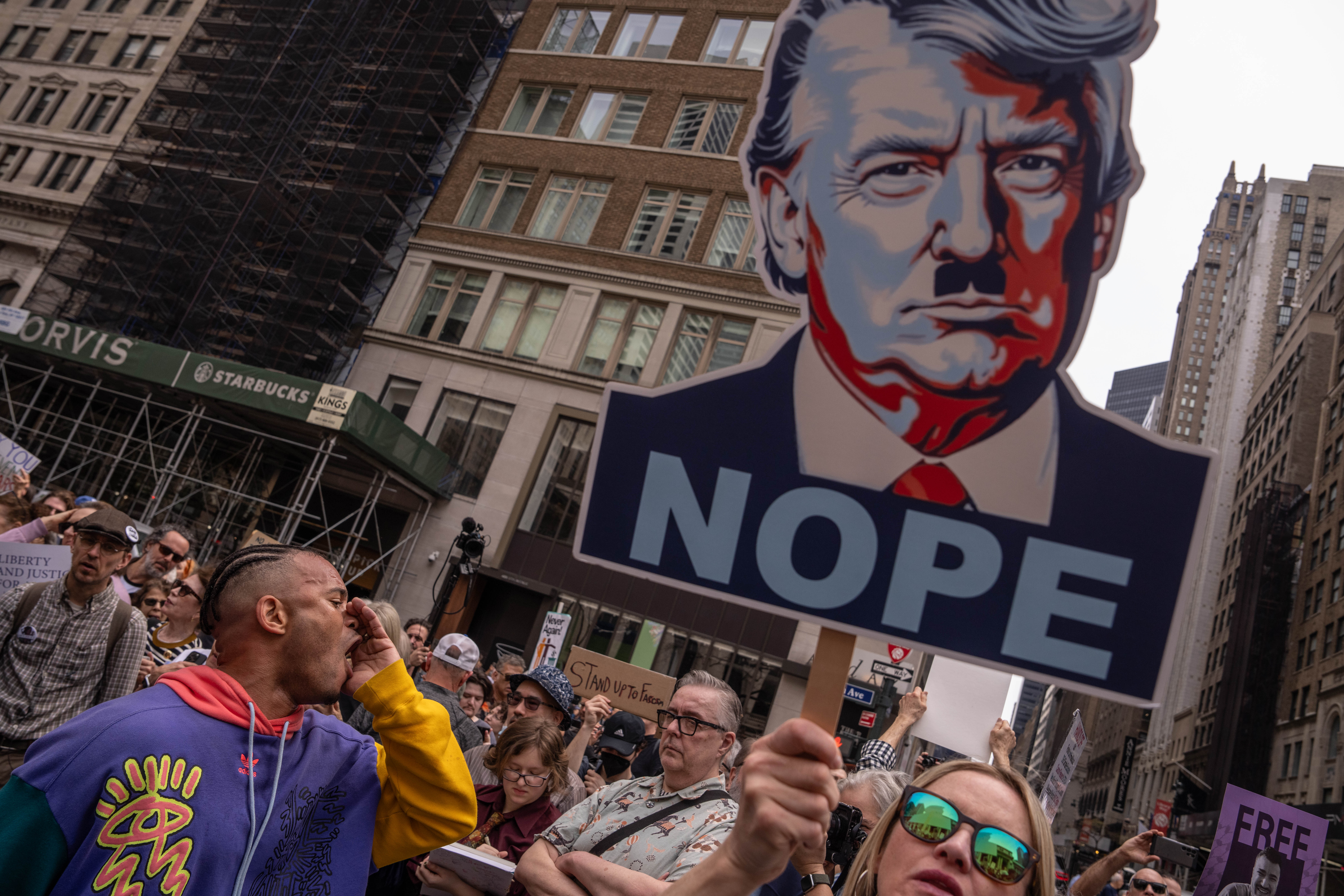 Protesters in New York City with a banner depicting Trump with a Hitler mustache