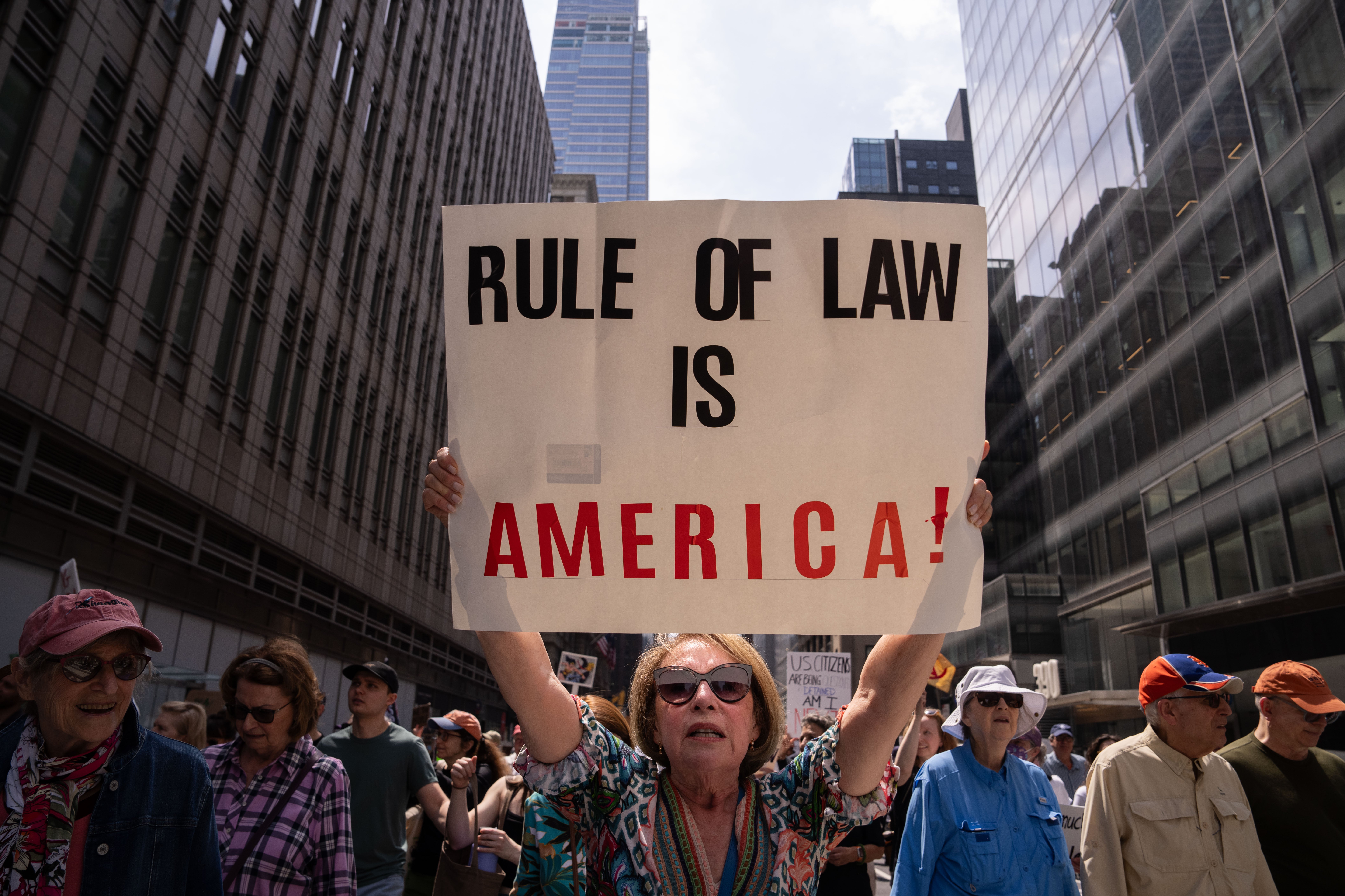 A protester in New York holds up a ‘Rule of law is America!’ sign, seemingly referring to recent admonishments by judges toward the Trump administration’s defiance of court orders