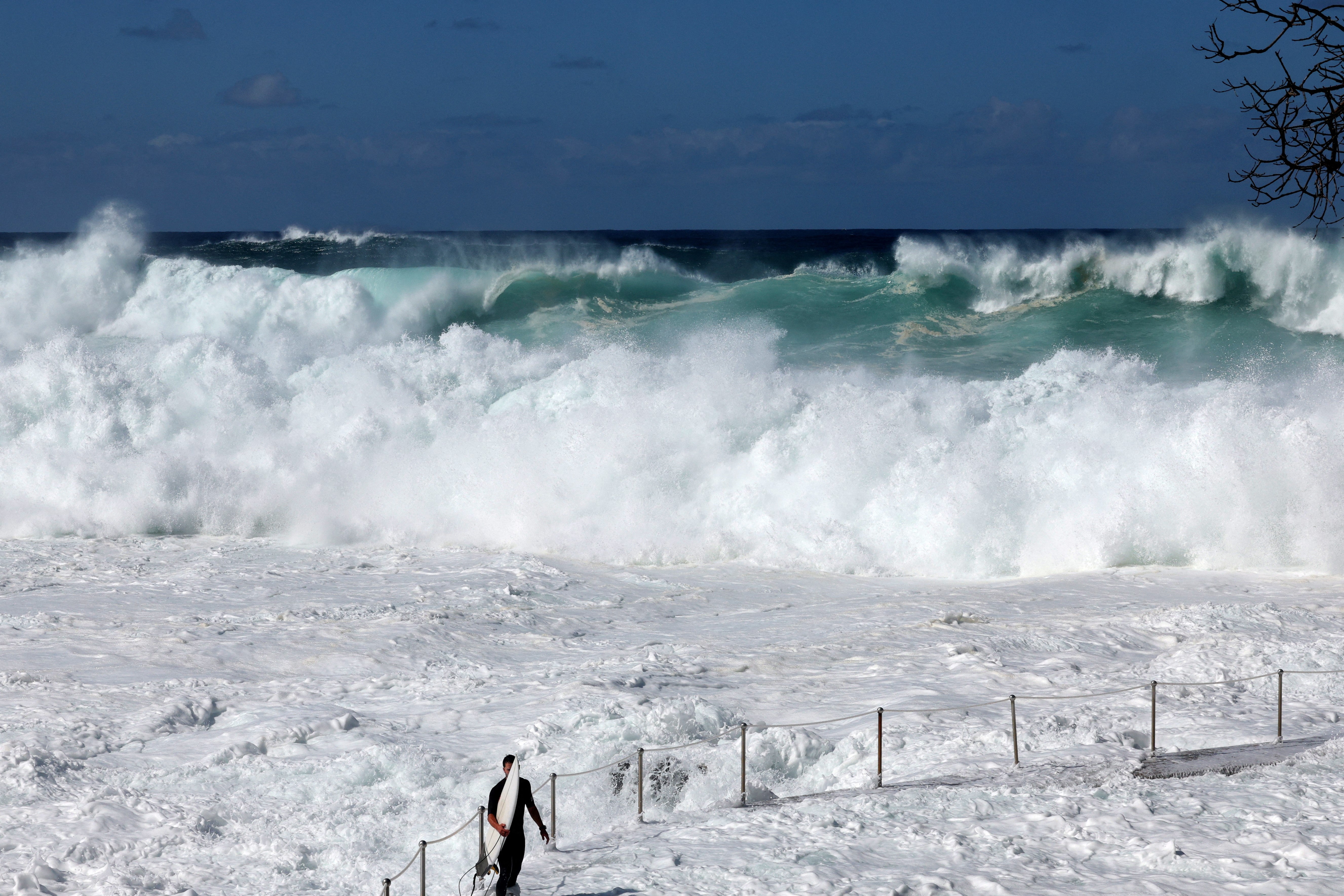 Surfer waits for a large wave on Bronte Beach in Sydney on 18 April 2025, amid powerful swells hitting Australia's east coast