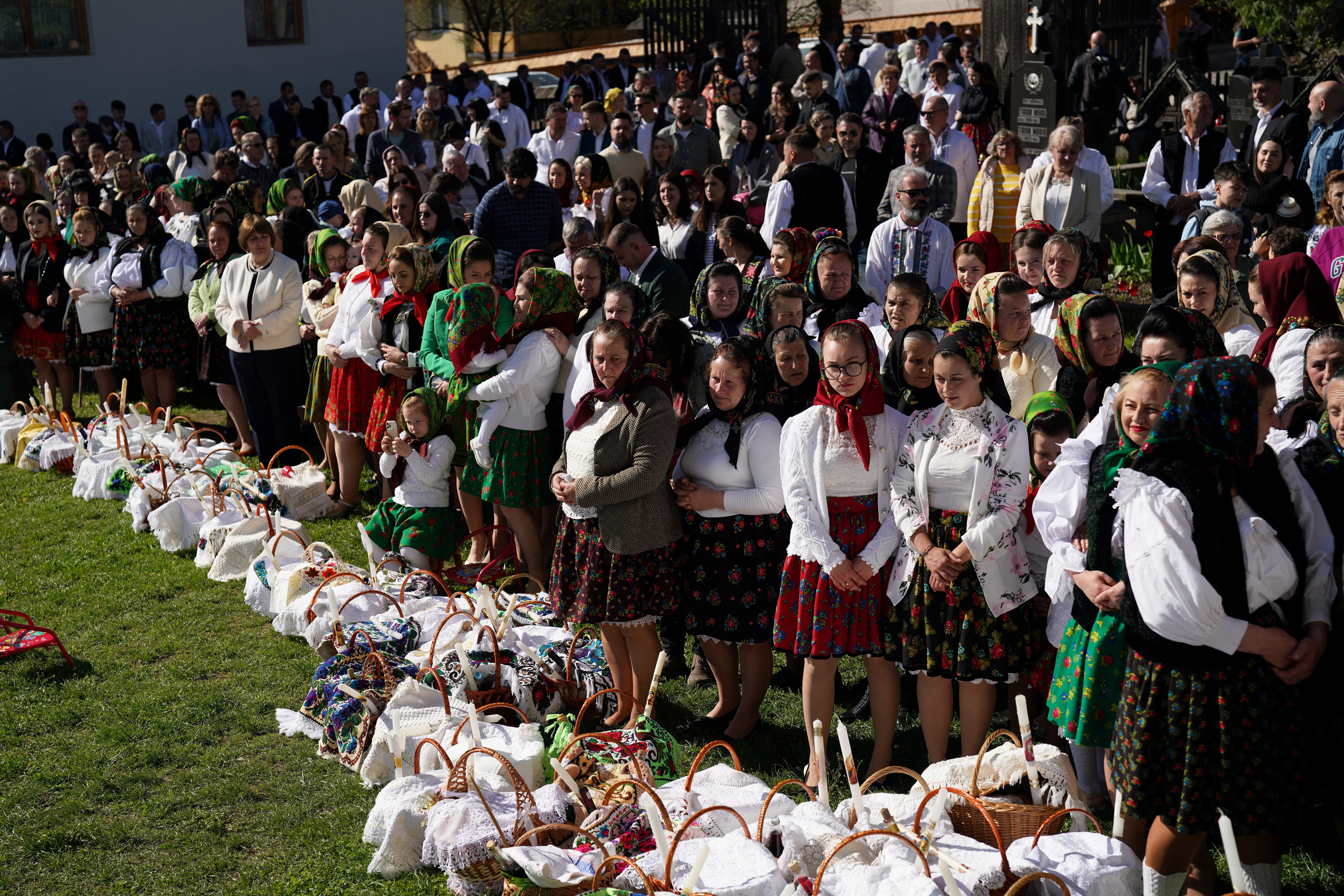 People dressed in traditional clothes attend the Easter service in the Northern region of Maramures in Breb, Romania, on Sunday