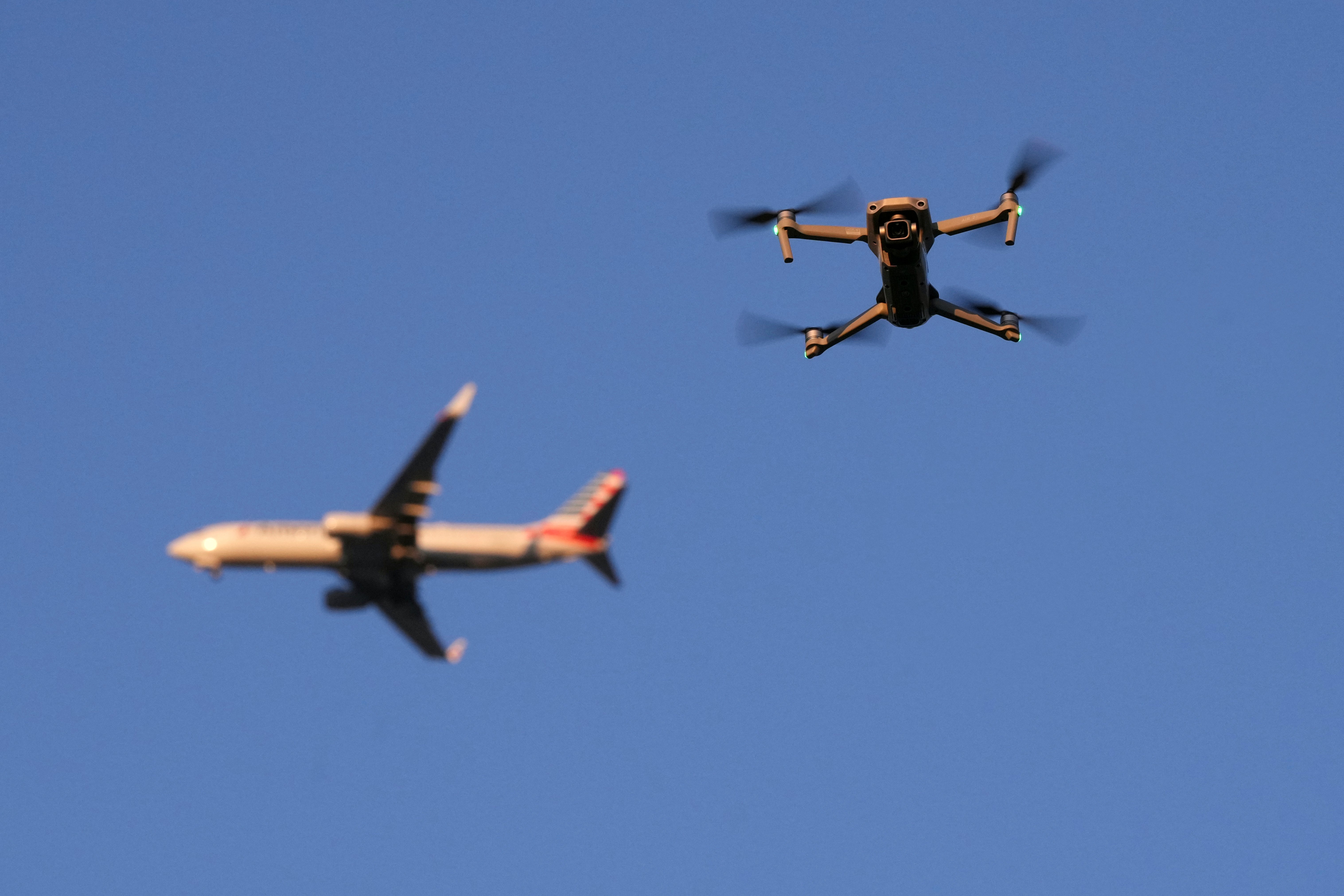 A drone hovers in airspace outside the safety perimeter surrounding St. Louis Lambert International Airport as an airliner approaches for a landing on March 10, 2025. (AP Photo/Jeff Roberson)