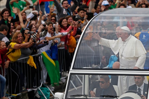 Pope Francis waves from the popemobile as he rides along the Copacabana beachfront on his way to celebrate mass for World Youth Day, in Rio de Janeiro, Brazil, Sunday, July 28, 2013. (AP Photo/Silvia Izquierdo, File)