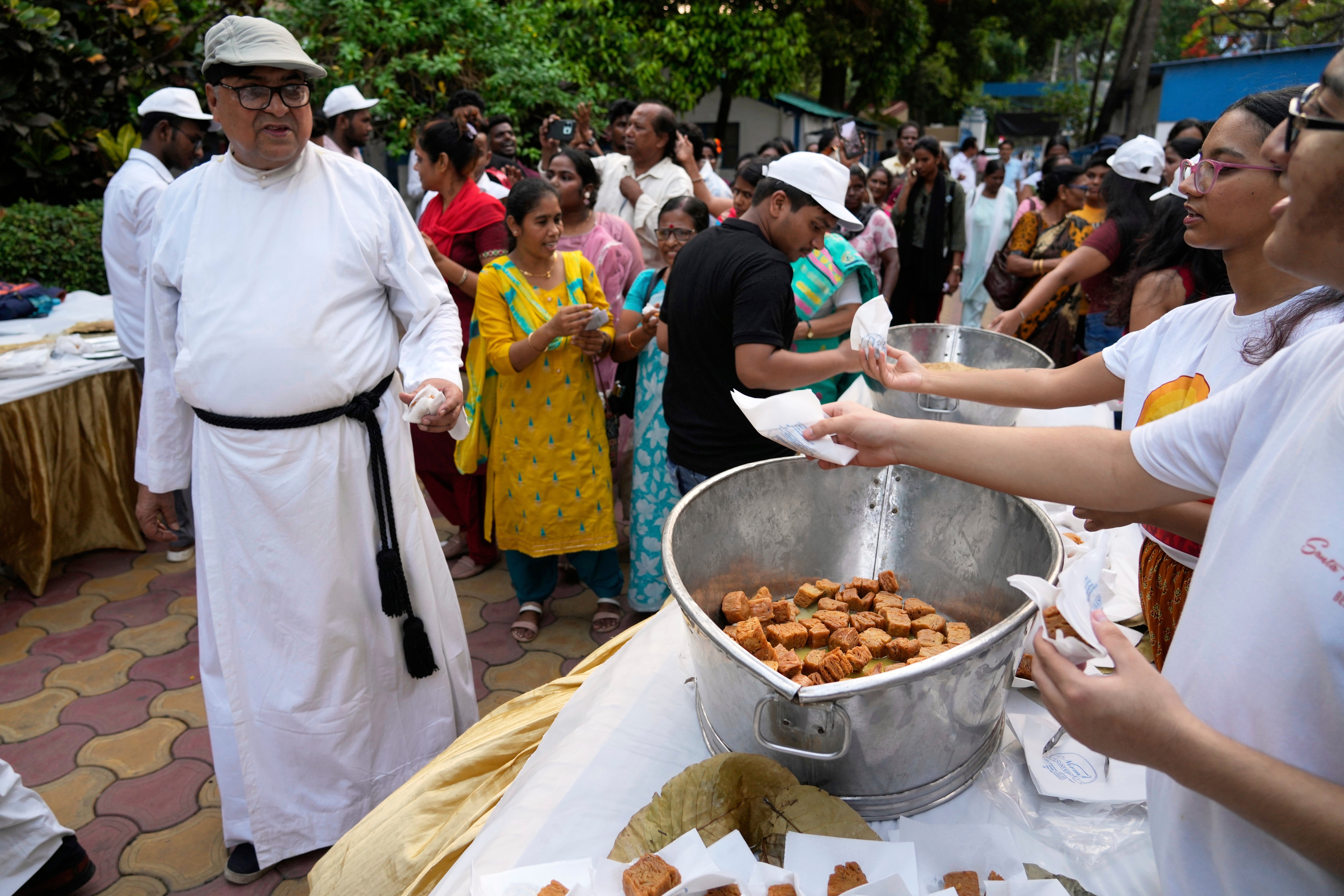 Representative: Volunteers offer sweets to a Catholic priest and others at the end of a procession celebrating Easter Sunday commemorating the day in Kolkata, India