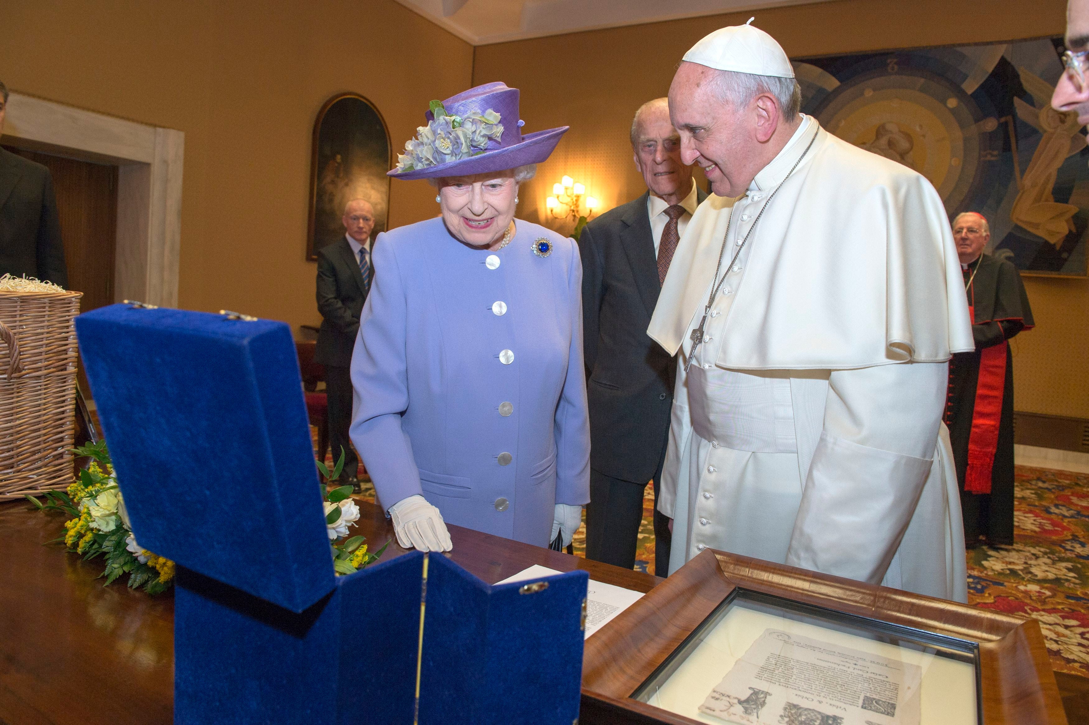 Queen Elizabeth II with Pope Francis look at a papal gift to Prince George as they met at the Vatican in 2014 (Arthur Edwards/The Sun/PA)