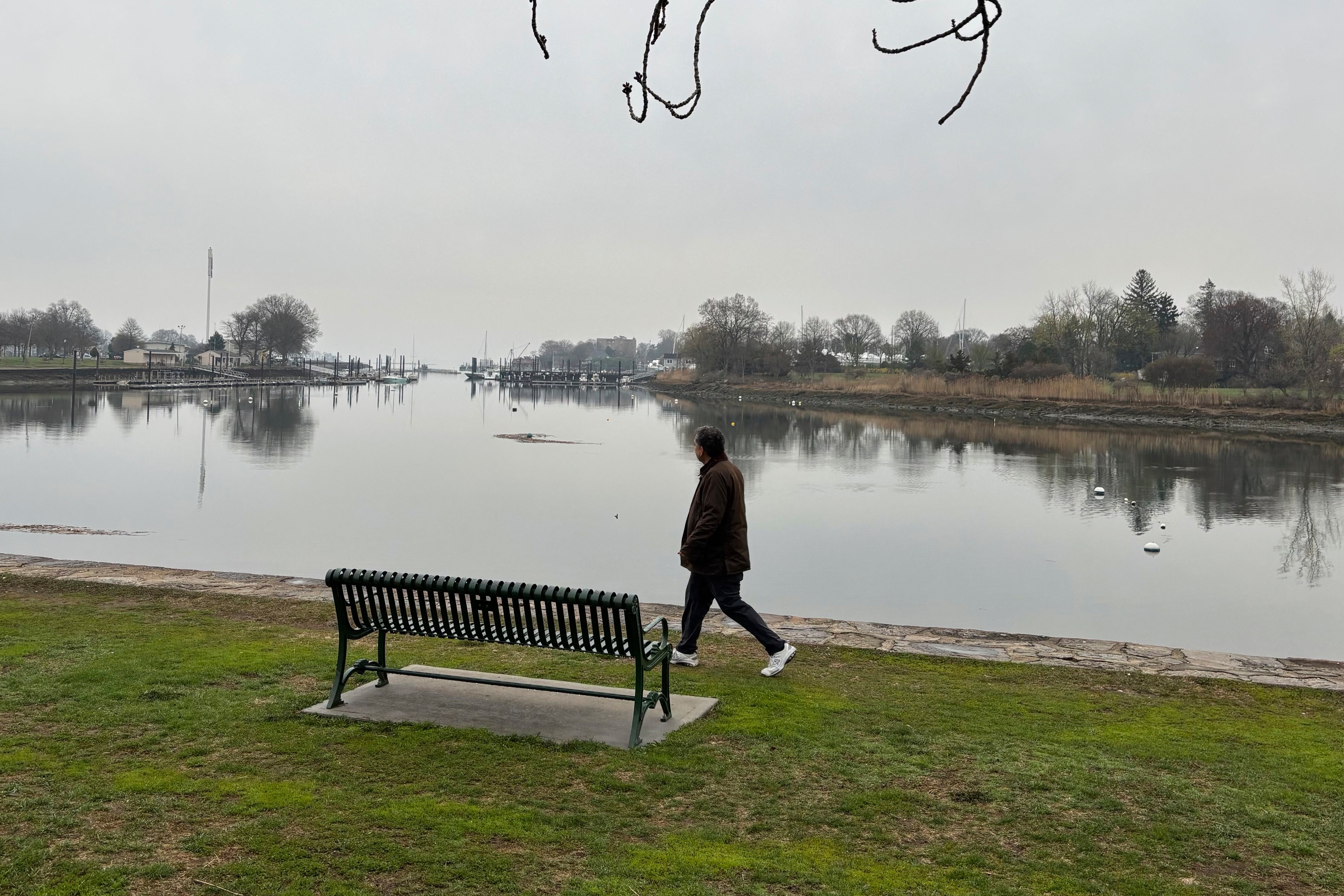 A man takes an early morning walk along Long Island Sound in Westchester County, N.Y. on Tuesday, April 15, 2025. (AP Photo/Julia Rubin)