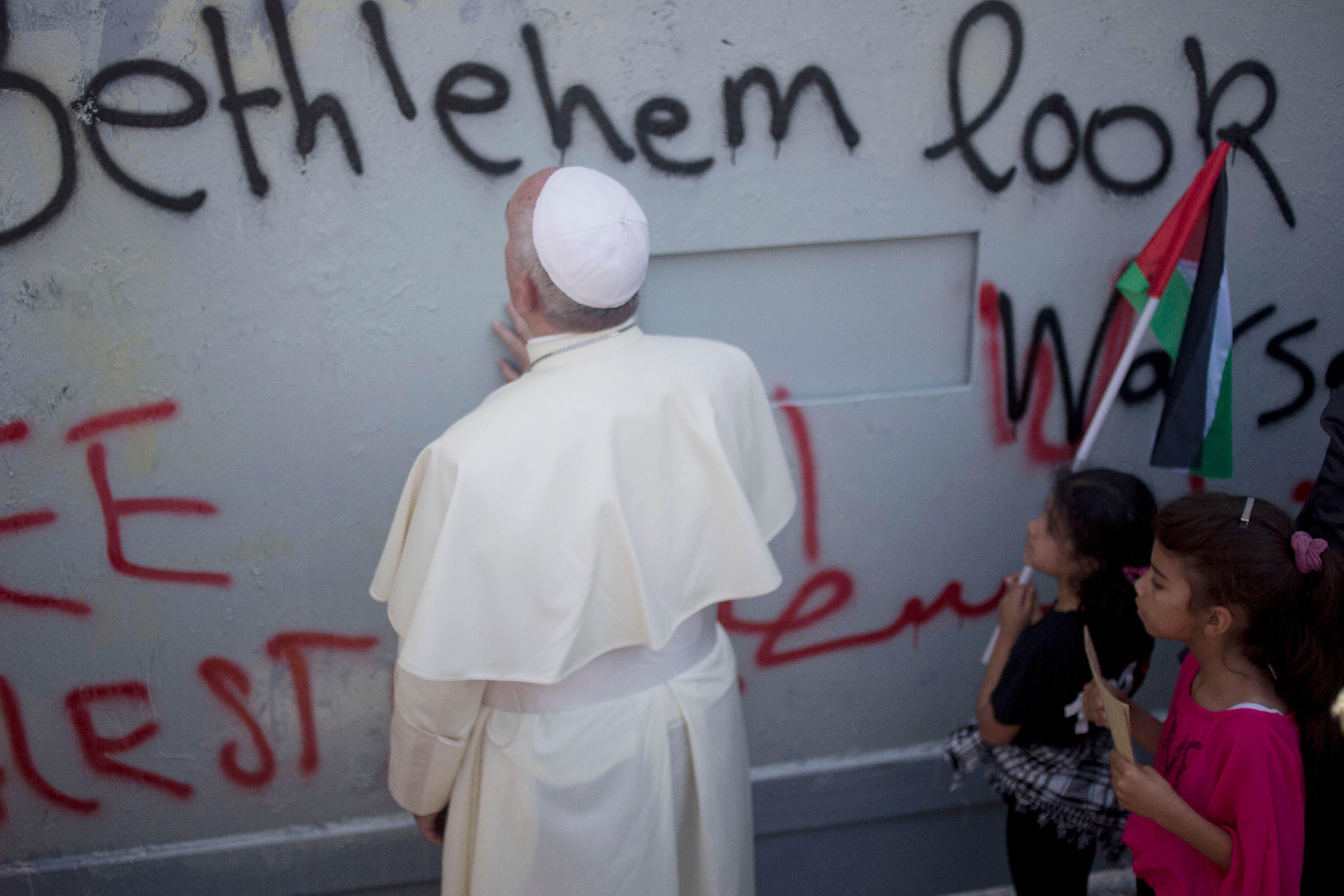 Pope Francis prays at Israel's separation barrier