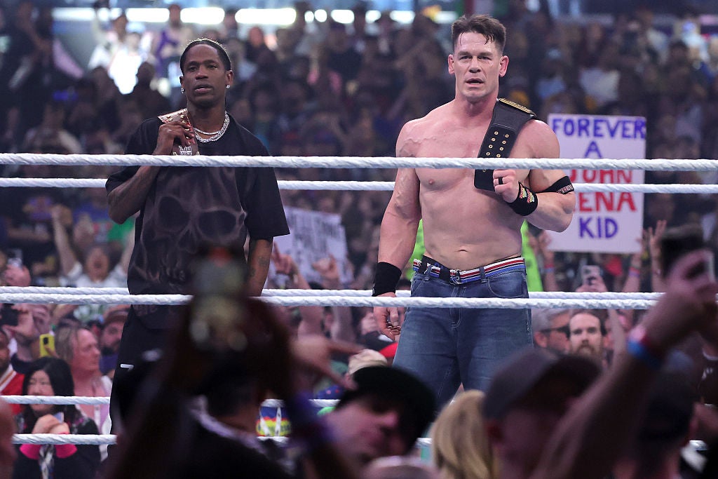 John Cena (R) celebrates with rapper Travis Scott after defeating Cody Rhodes for the Undisputed WWE Championship during WrestleMania 41