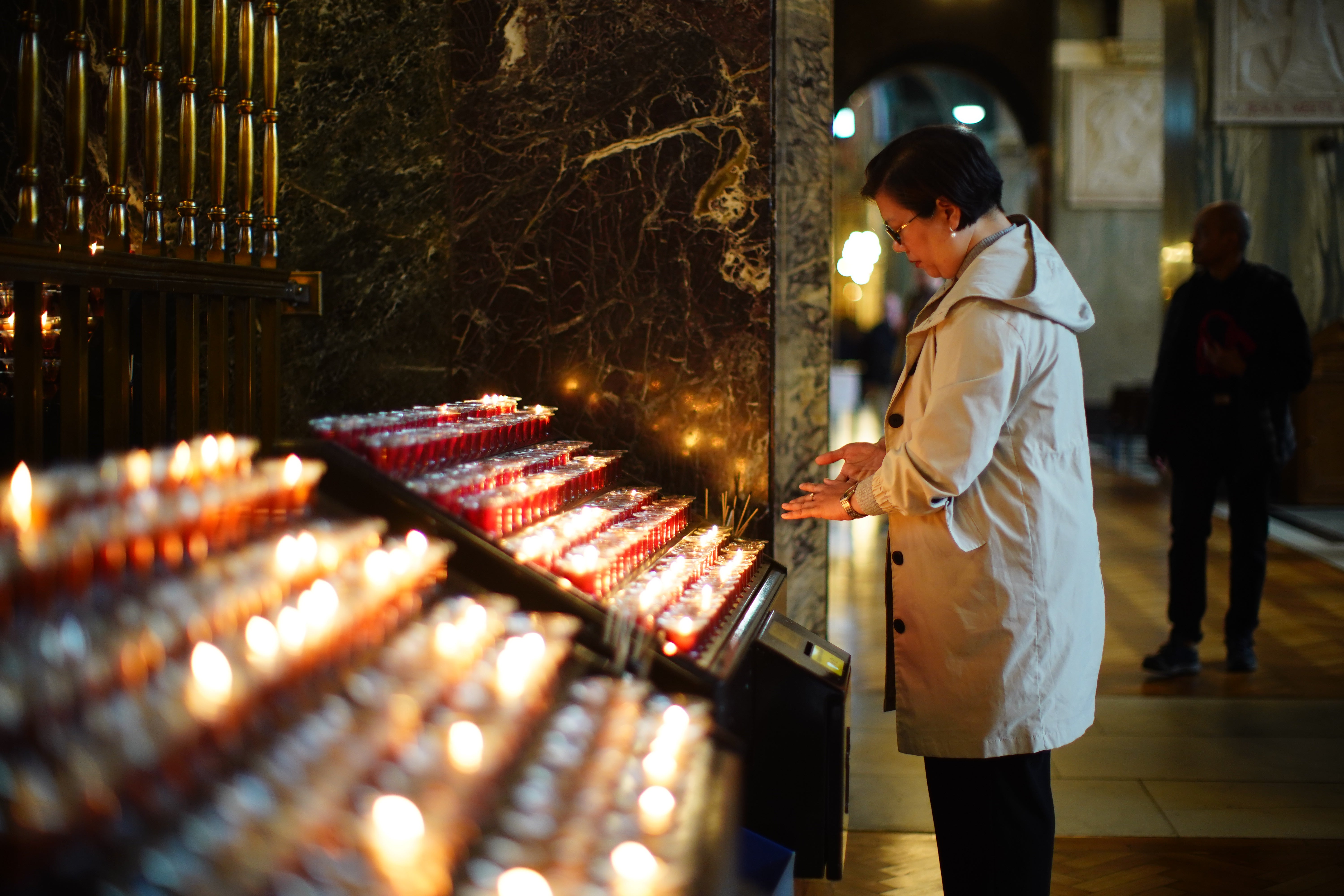 Mourners light candles at Westminster Cathedral in London on Monday