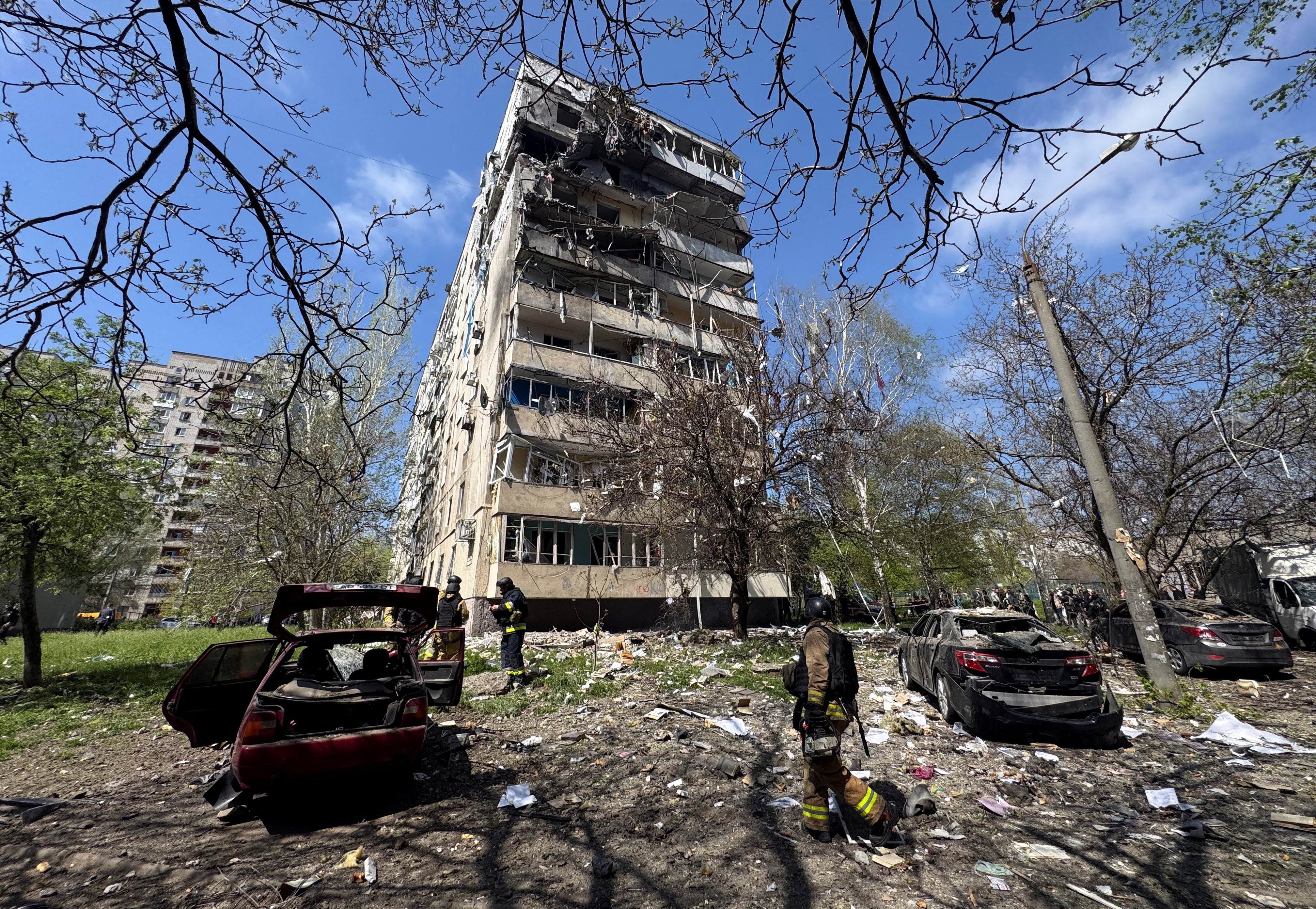 Rescuers work at a site of an apartment building hit by a Russian air strike in Zaporizhzhia, Ukraine, on Tuesday