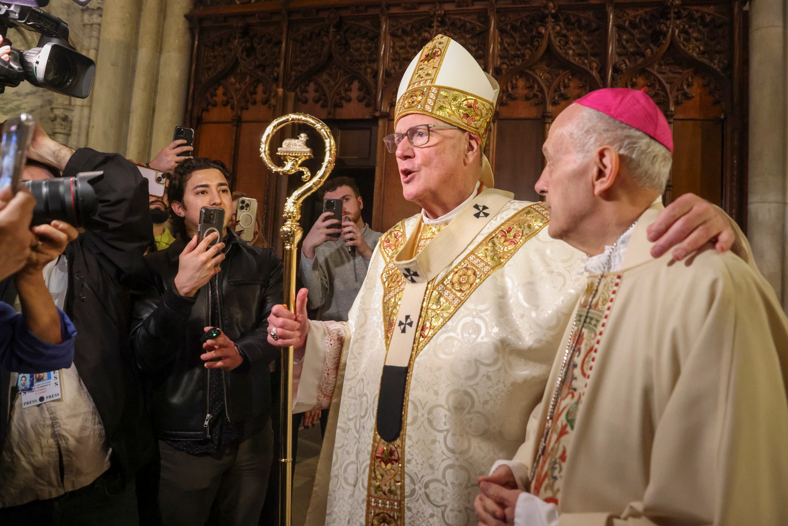 Archbishop of New York Timothy Dolan (C) and Permanent Observer of the Holy See to the United Nations, Archbishop Gabriele Giordano Caccia (R) speak to the press following a mass for the repose of the soul of the late Pope Francis at St. Patrick's Cathedral in New York