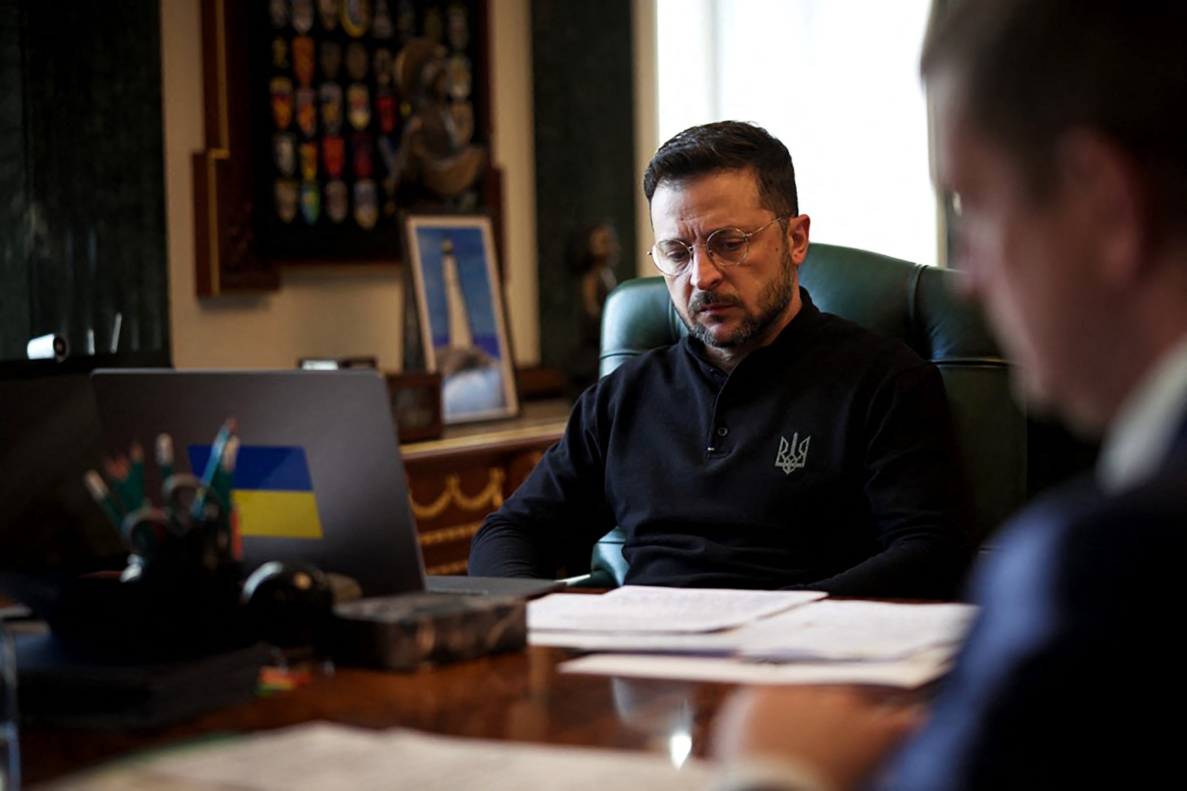 Ukraine's president Volodymyr Zelensky waits for a phone call with Britain's prime minister Keir Starmer as he sits at his desk in his office in Kyiv