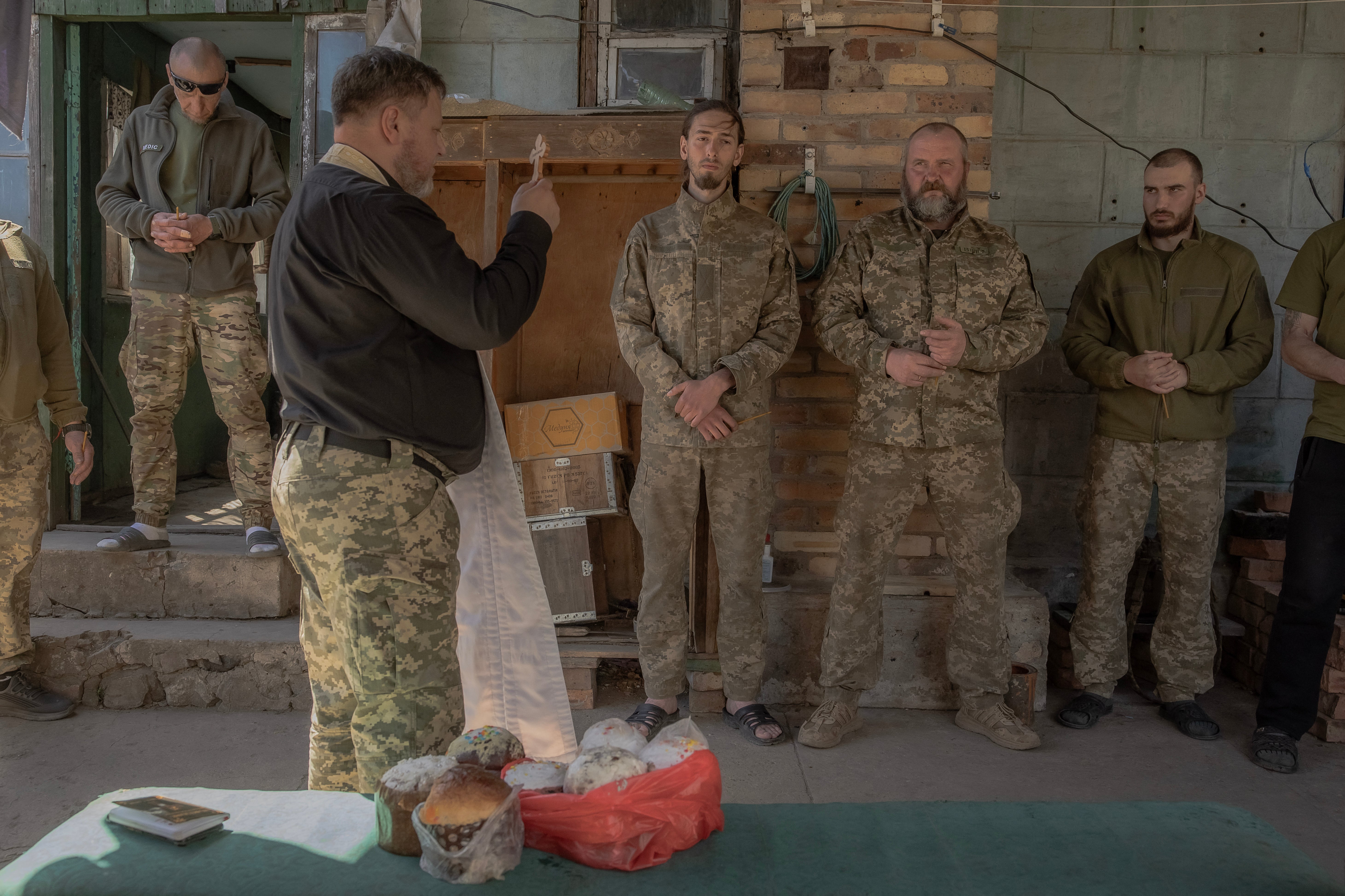 A military chaplain blesses Ukrainian servicemen of the 100th brigade and traditional cakes to celebrate Orthodox Easter, in the Donetsk region