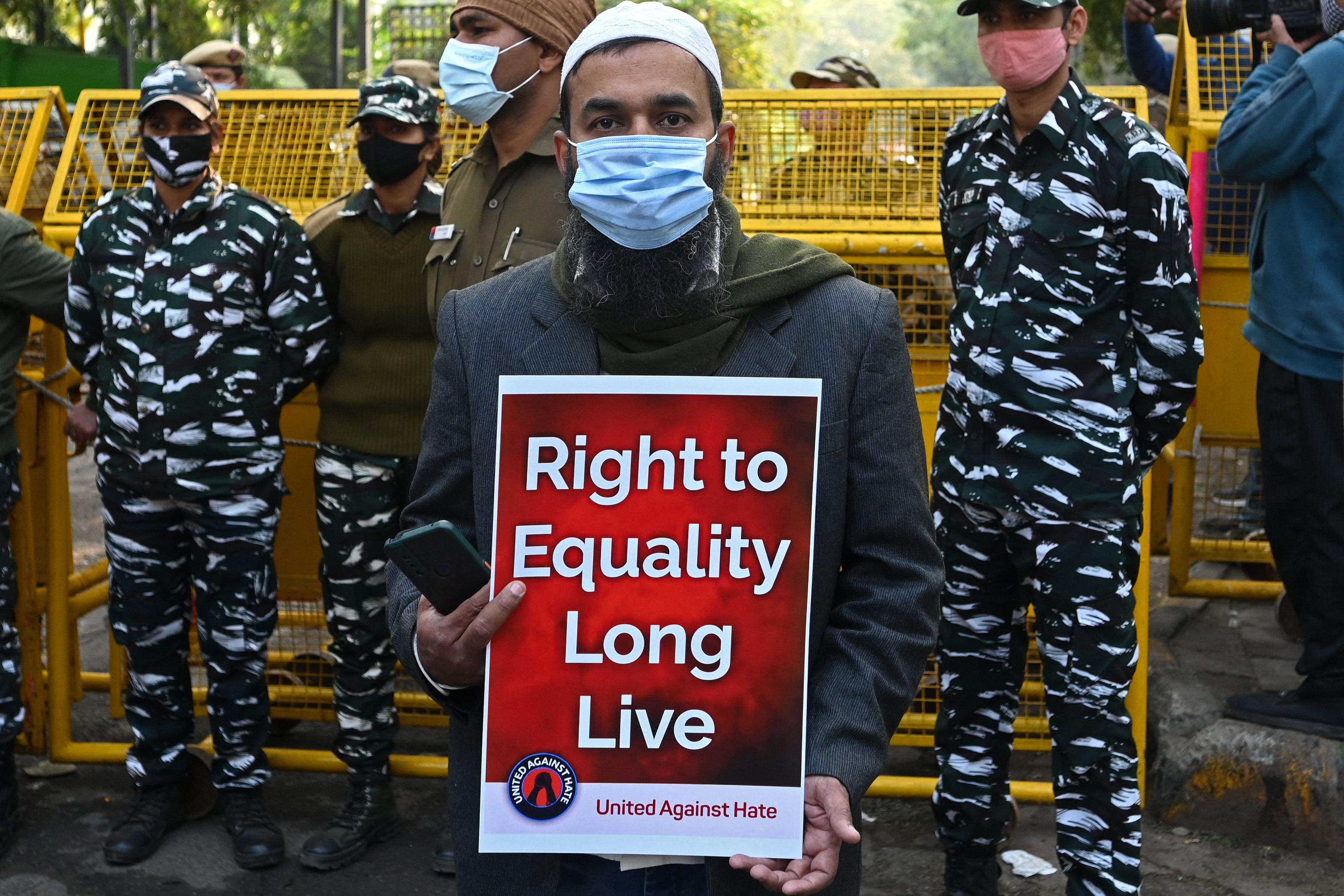 A protester holds a placard during a demonstration in New Delhi on 27 December 2021 after police started an investigation into an event where Hindu hardliners called for mass killings of minority Muslims