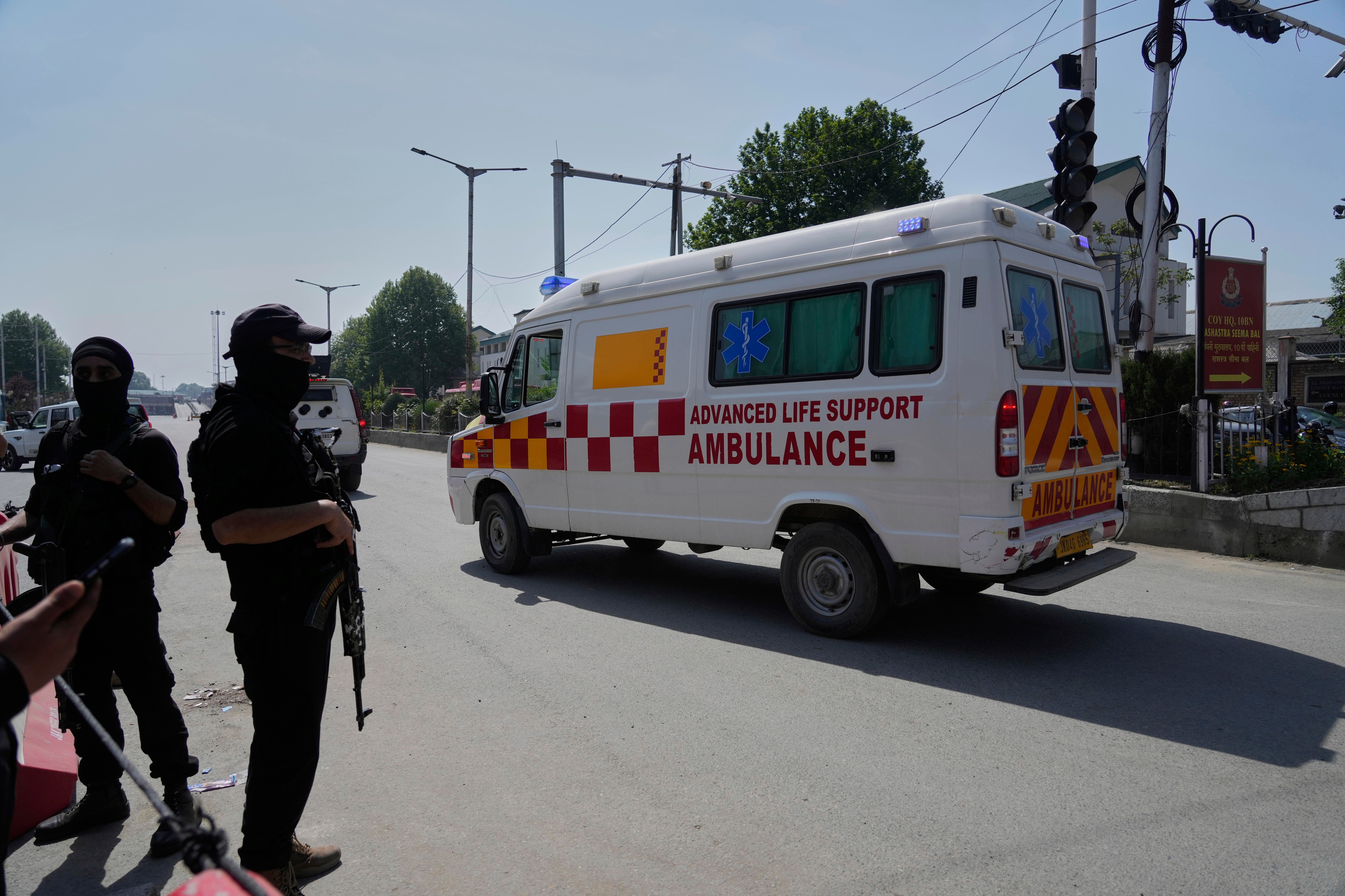 Police stand guard as ambulances transport tourists to hospital following a deadly shooting