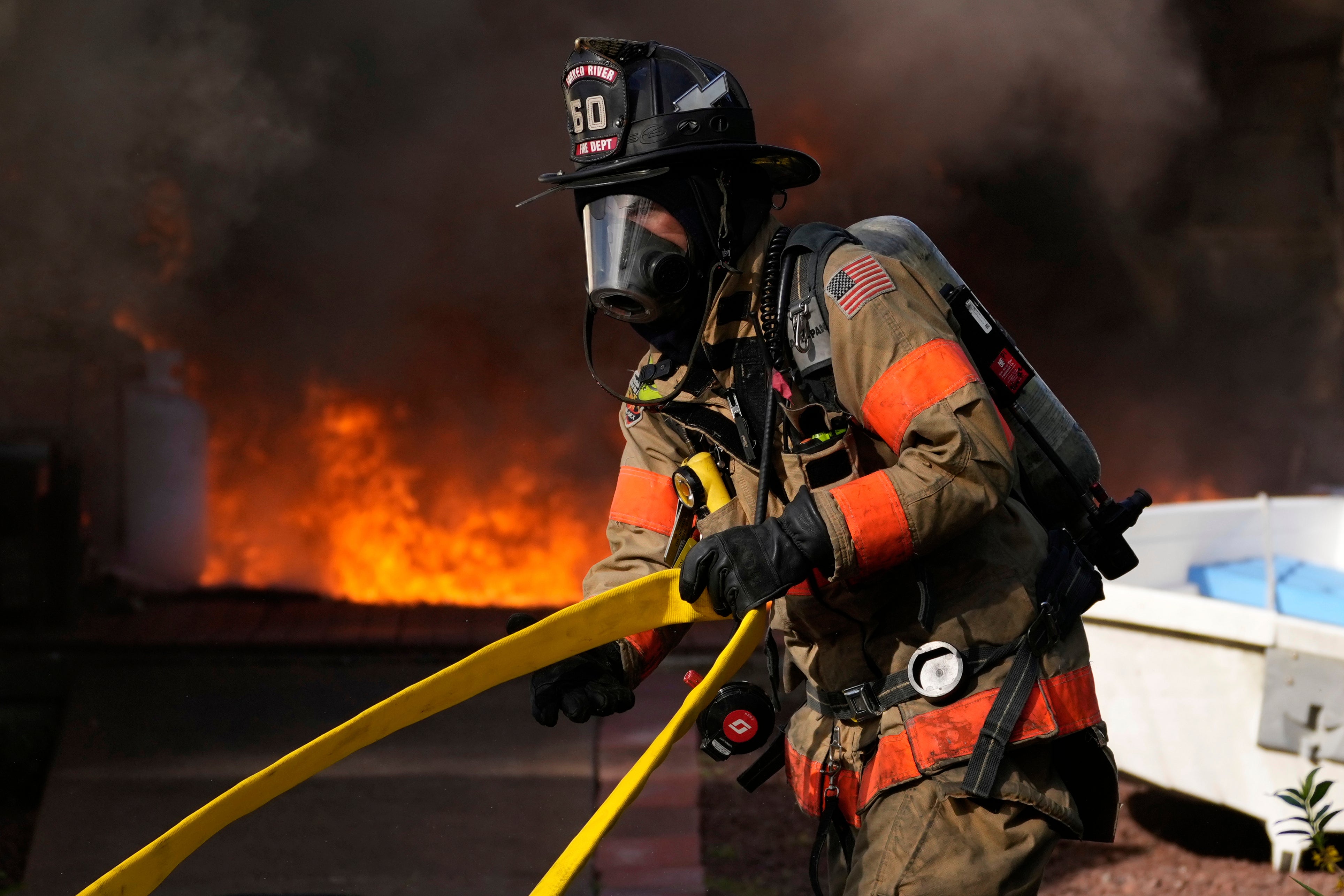 Firefighters battle a house fire in Lacey Township, N.J. on Wednesday