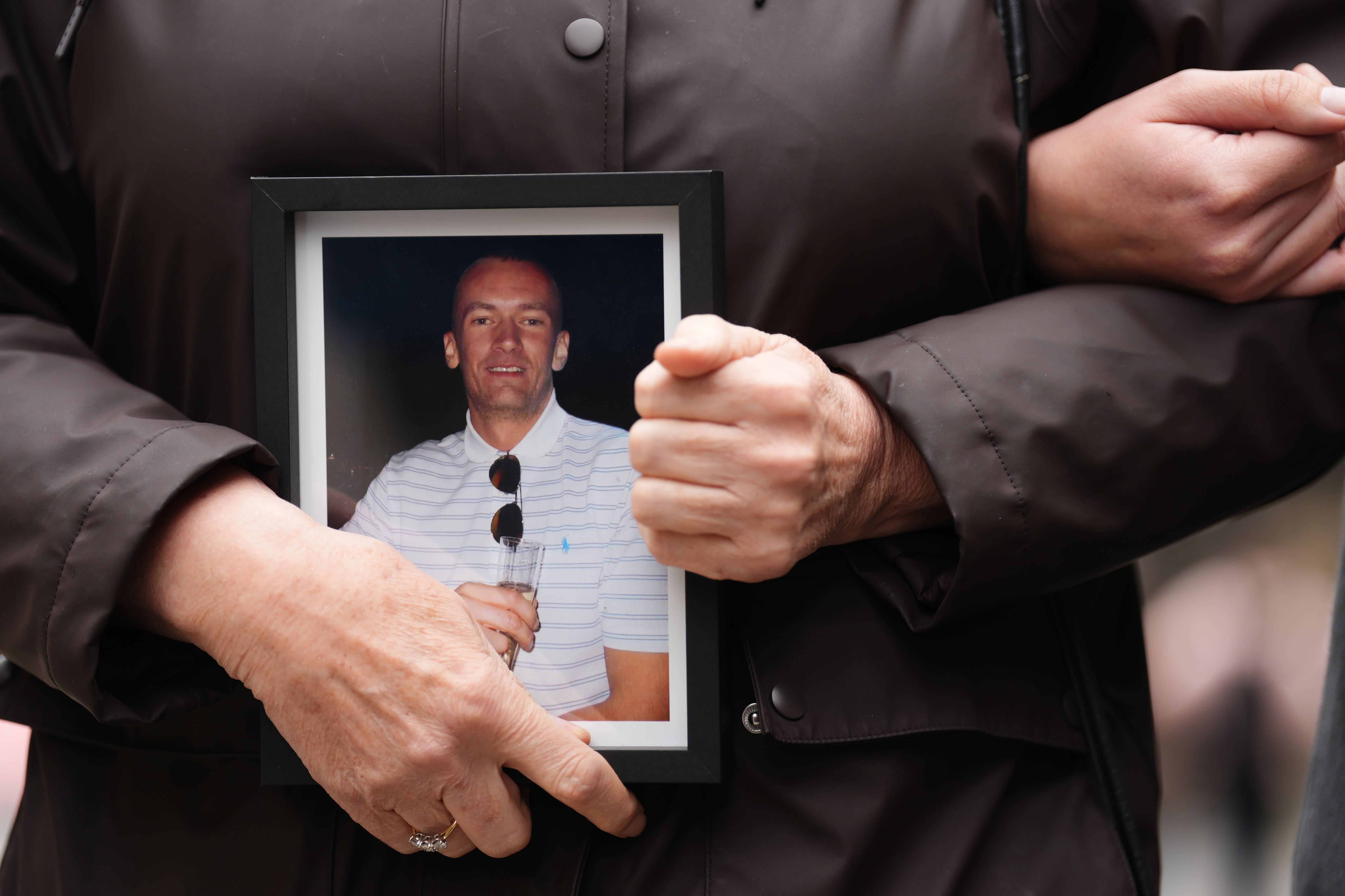 Jen Inglis, the mother of Calum Inglis, holds a picture of him (Andrew Milligan/PA)
