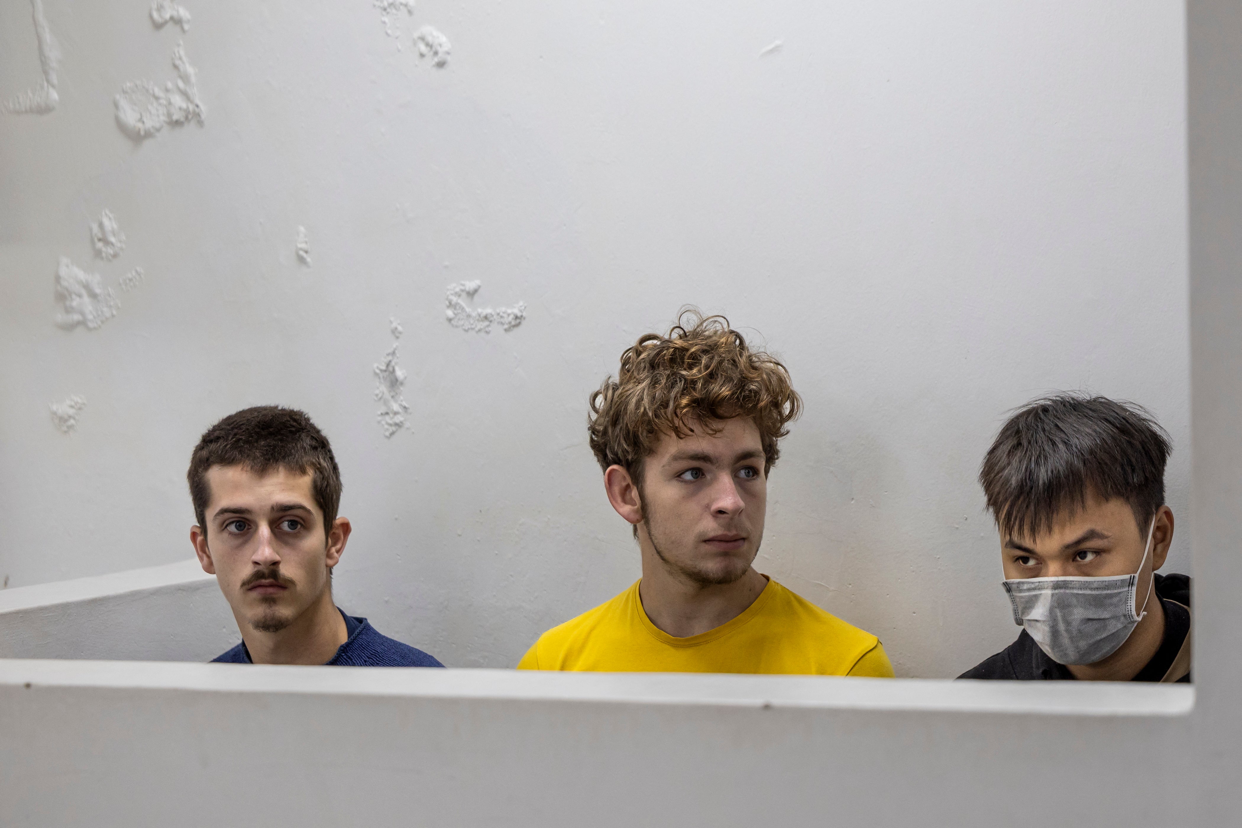 Belgian nationals Seppe Lodewijckx (L) and Lornoy David (C) sit with their co-accused Vietnamese Duh Hung Nguyen (R) in the dock for the mention of their case in which they are charged alongside a Kenyan national Dennis Ng'ang'a (unseen) with illegal possession and attempted export of protected wildlife in Nairobi on April 23, 2025