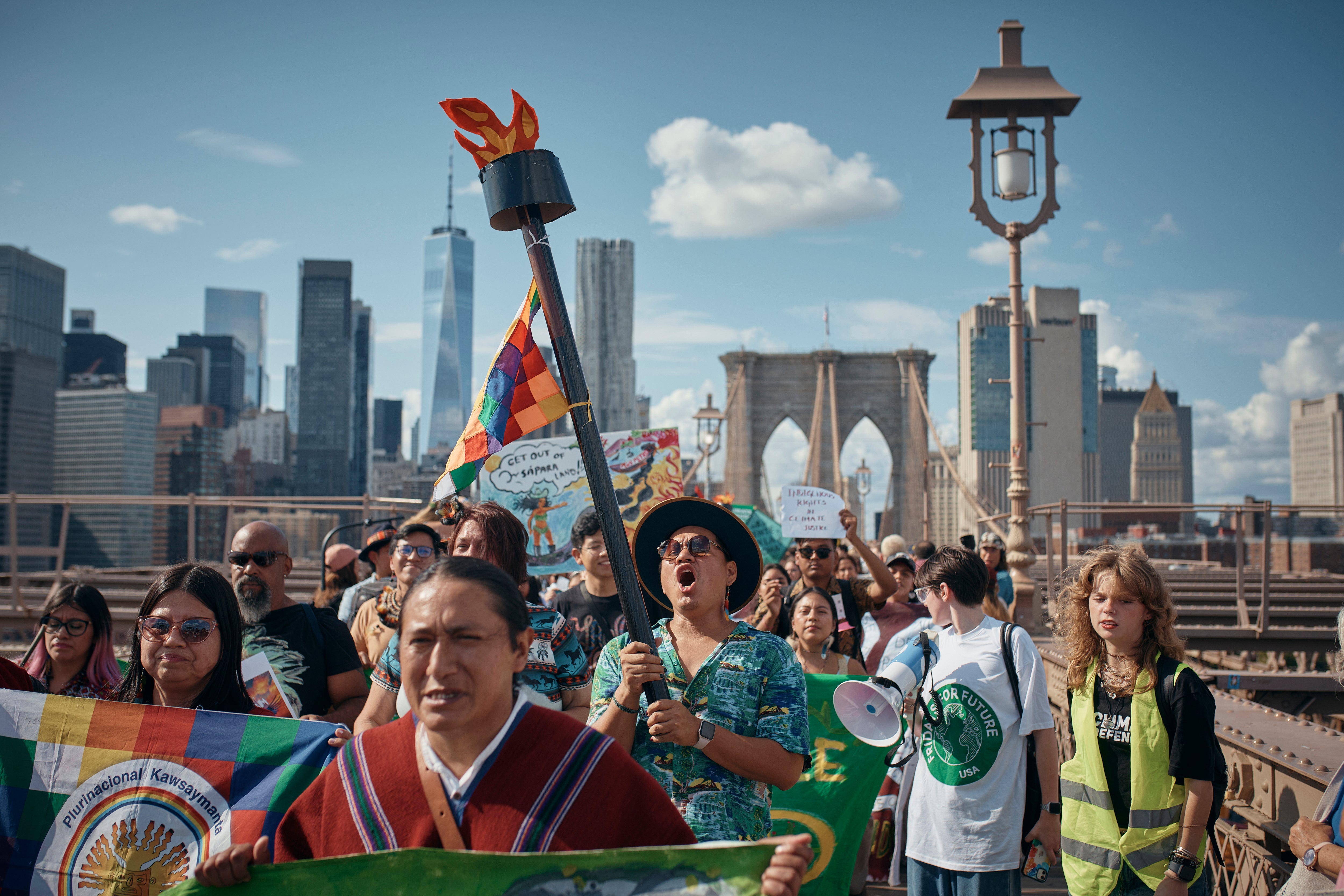Protesters shout slogans as they cross the Brooklyn Bridge during a Youth Climate Strike march to demand an end to the era of fossil fuels
