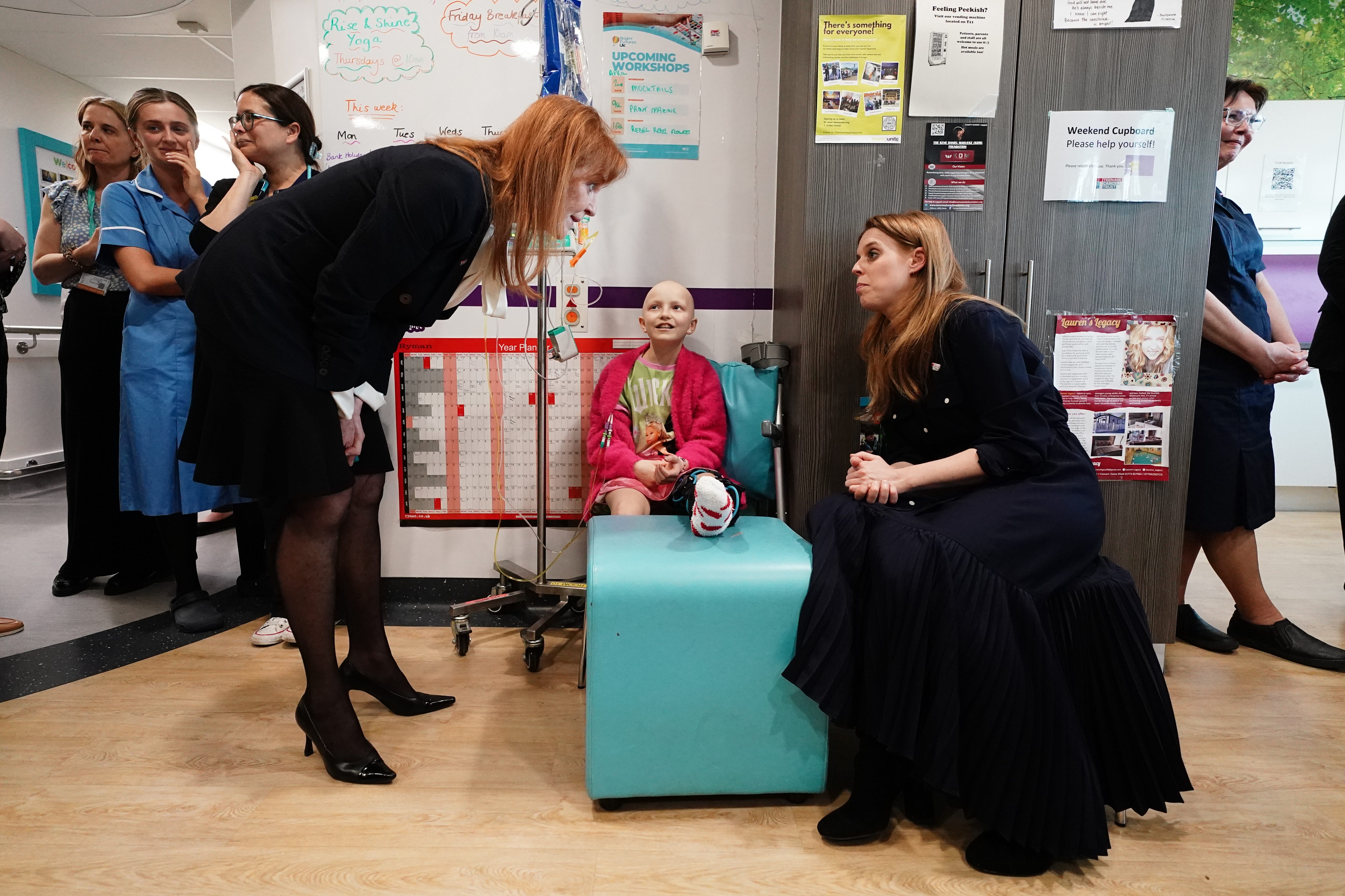 Sarah, Duchess of York and her daughter Princess Beatrice speak to a young cancer patient, Lola Belle Tucker, during a visit to the Teenage Cancer Trust unit at University College Hospital (Aaron Chown/PA)