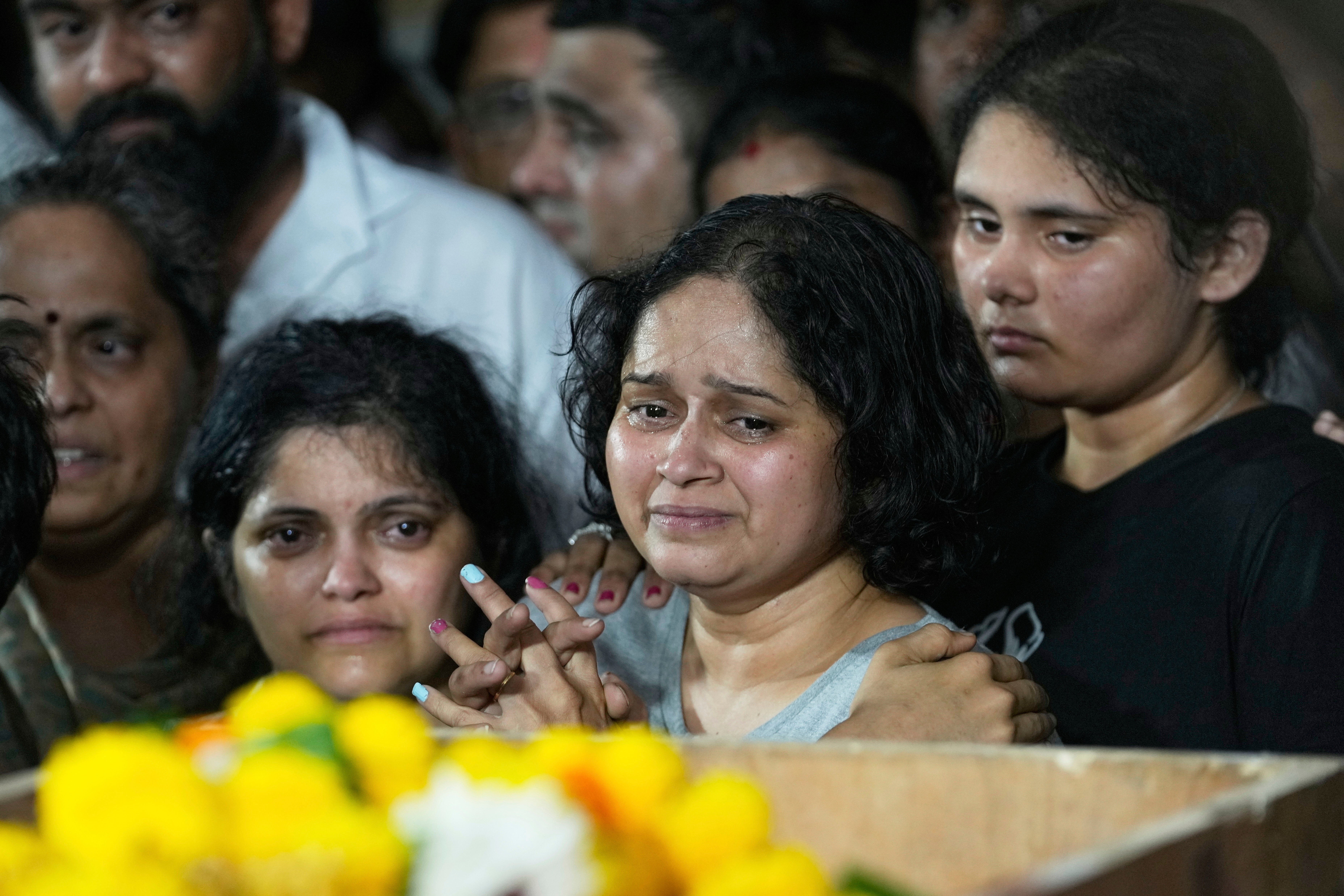 The wife of Atul Mone, who was victim in a deadly attack on tourists in the Pahalgam region of Indian-administered Kashmir, mourns as she stands near her husband's body at Dombivali near Mumbai