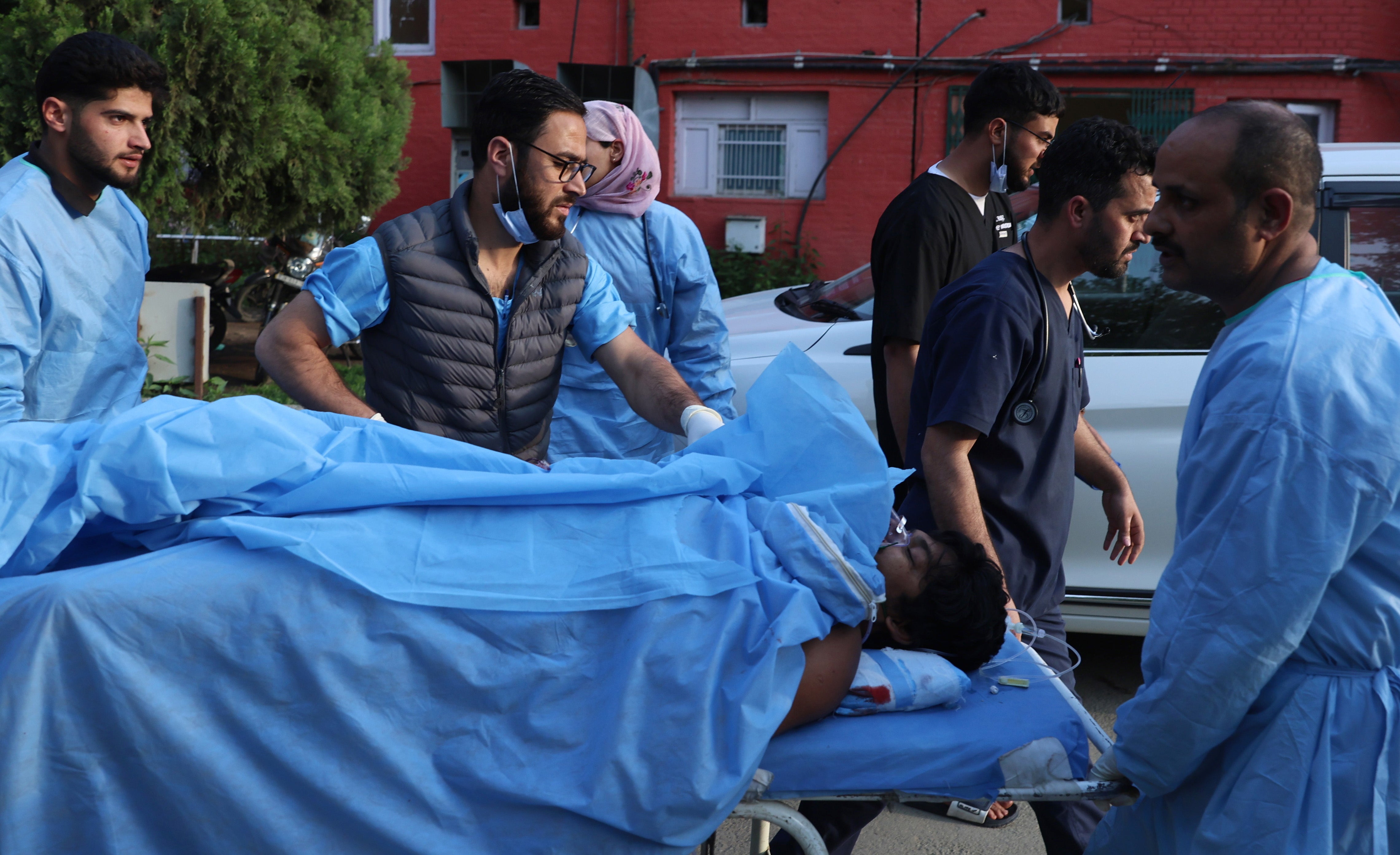 Paramedics transport an injured tourist at a hospital in the town of Anantnag near Pahalgam