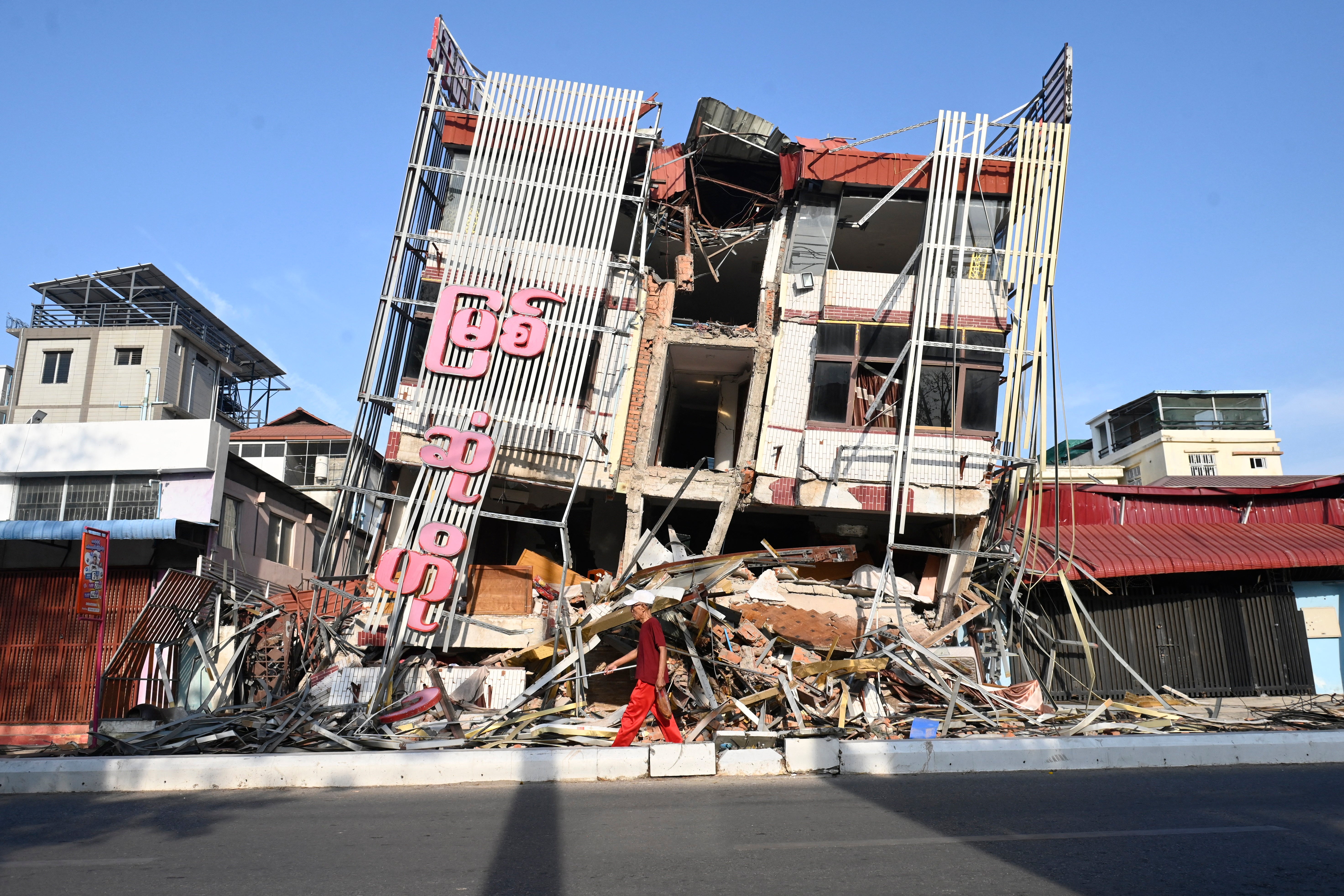 A man walk past a damaged building in Mandalay on 13 April following the devastating 28 March earthquake.