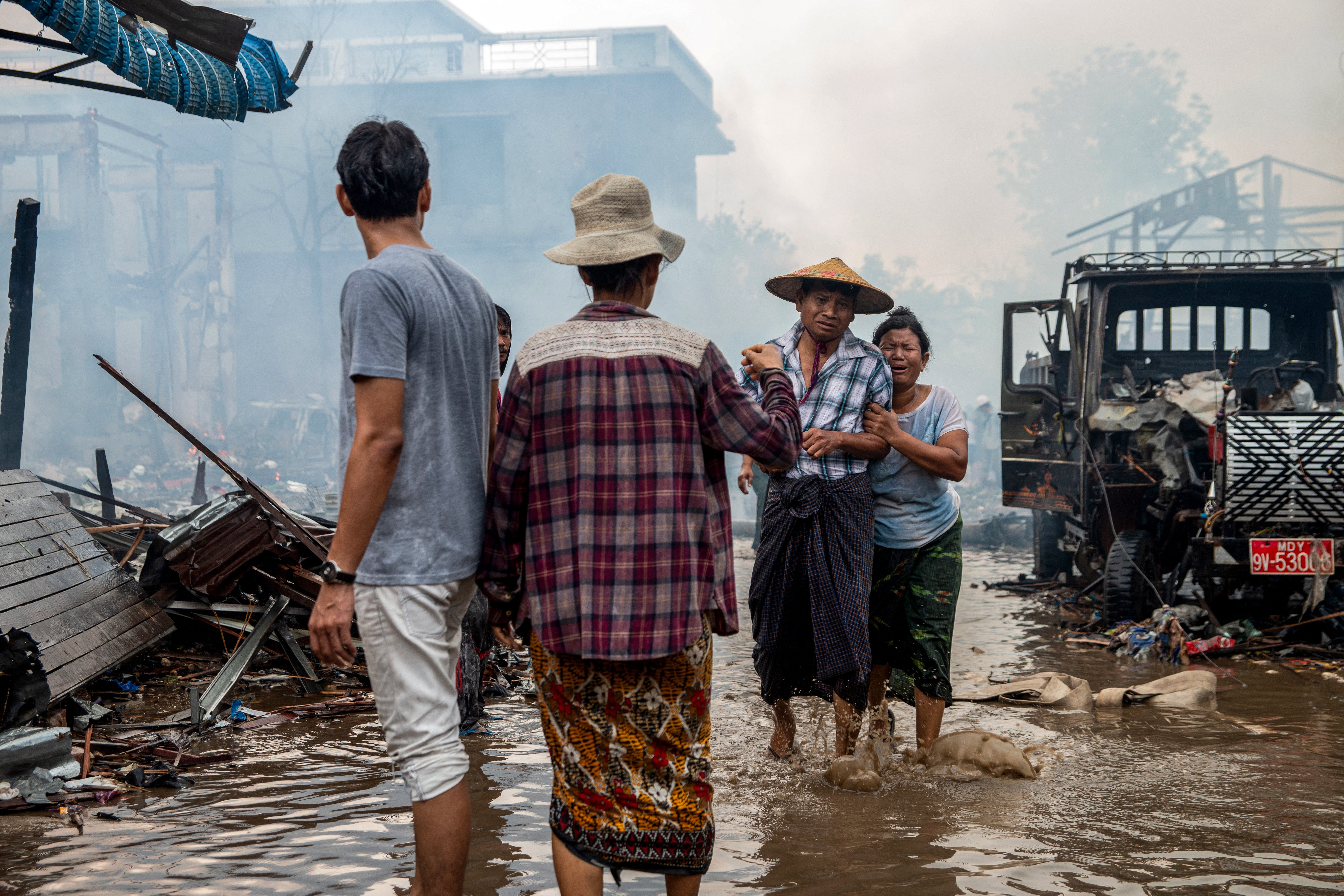 People cry as their family members have been killed in a bombardment carried out by Myanmar's military in Thabeikkyin Township
