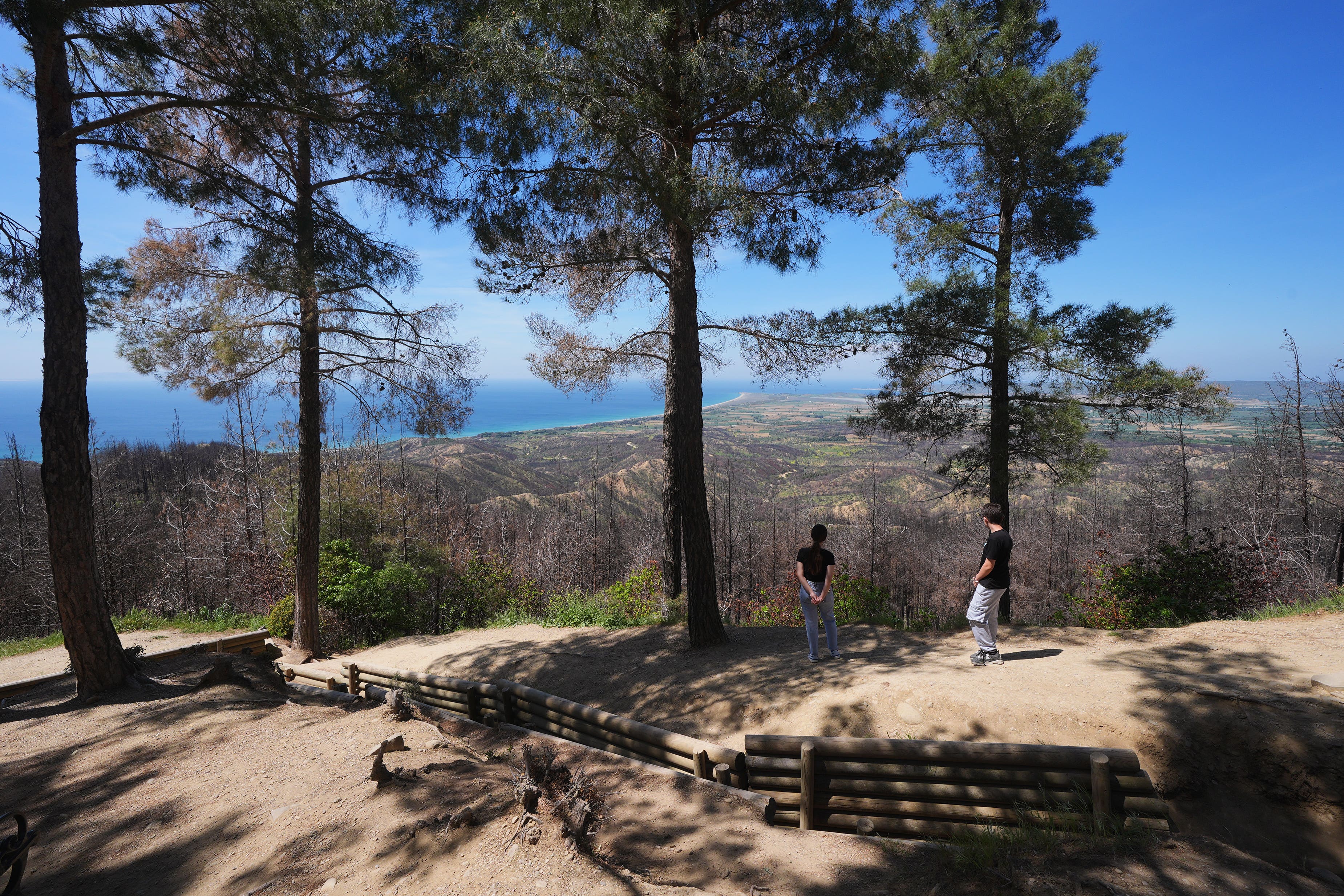 Visitors stand next to trenches at Chunuk Bair Cemetery – which commemorates New Zealand soldiers who died during the Gallipoli campaign (PA)