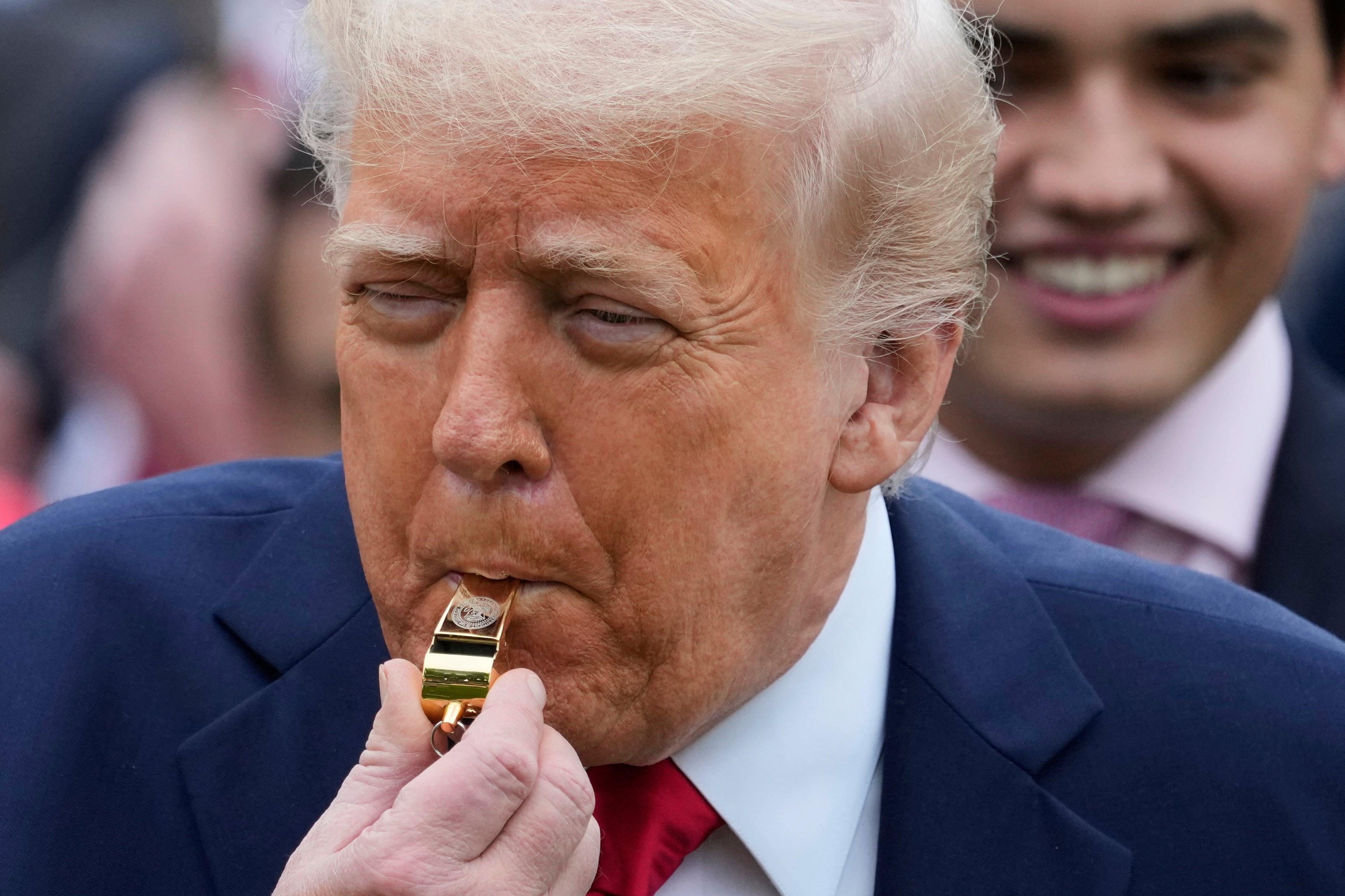 Donald Trump blows a gold whistle to start the 2025 White House Easter Egg Roll