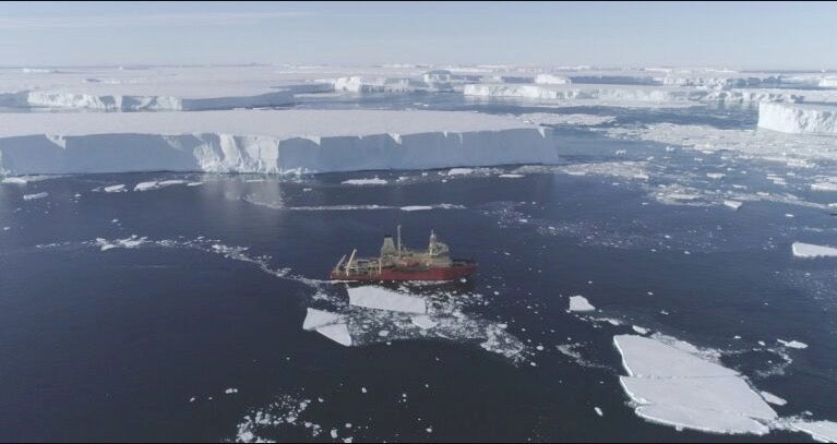 The US research ship RV Nathaniel B Palmer is dwarfed by giant tabular icebergs