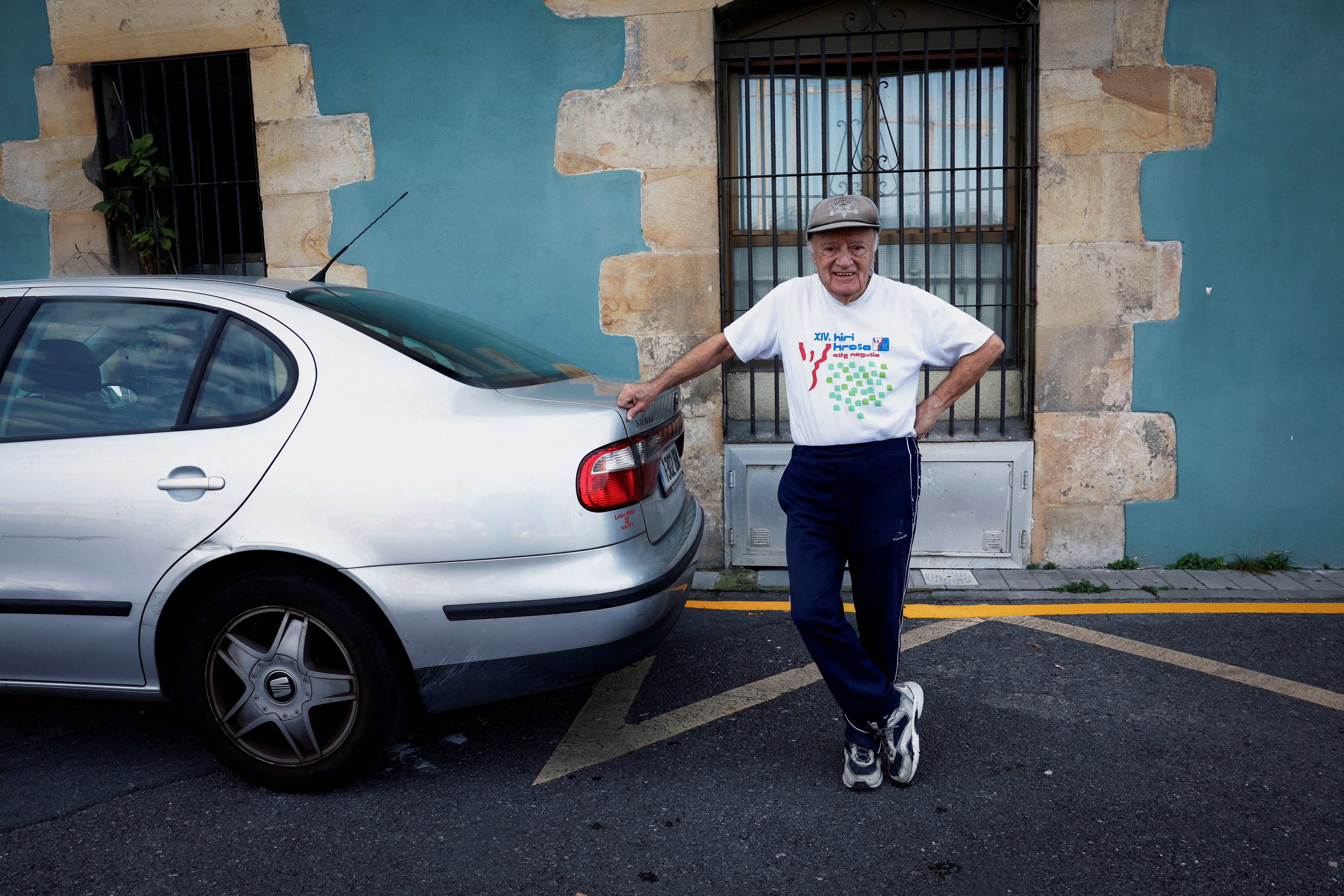 Albizu poses for a picture next to his car